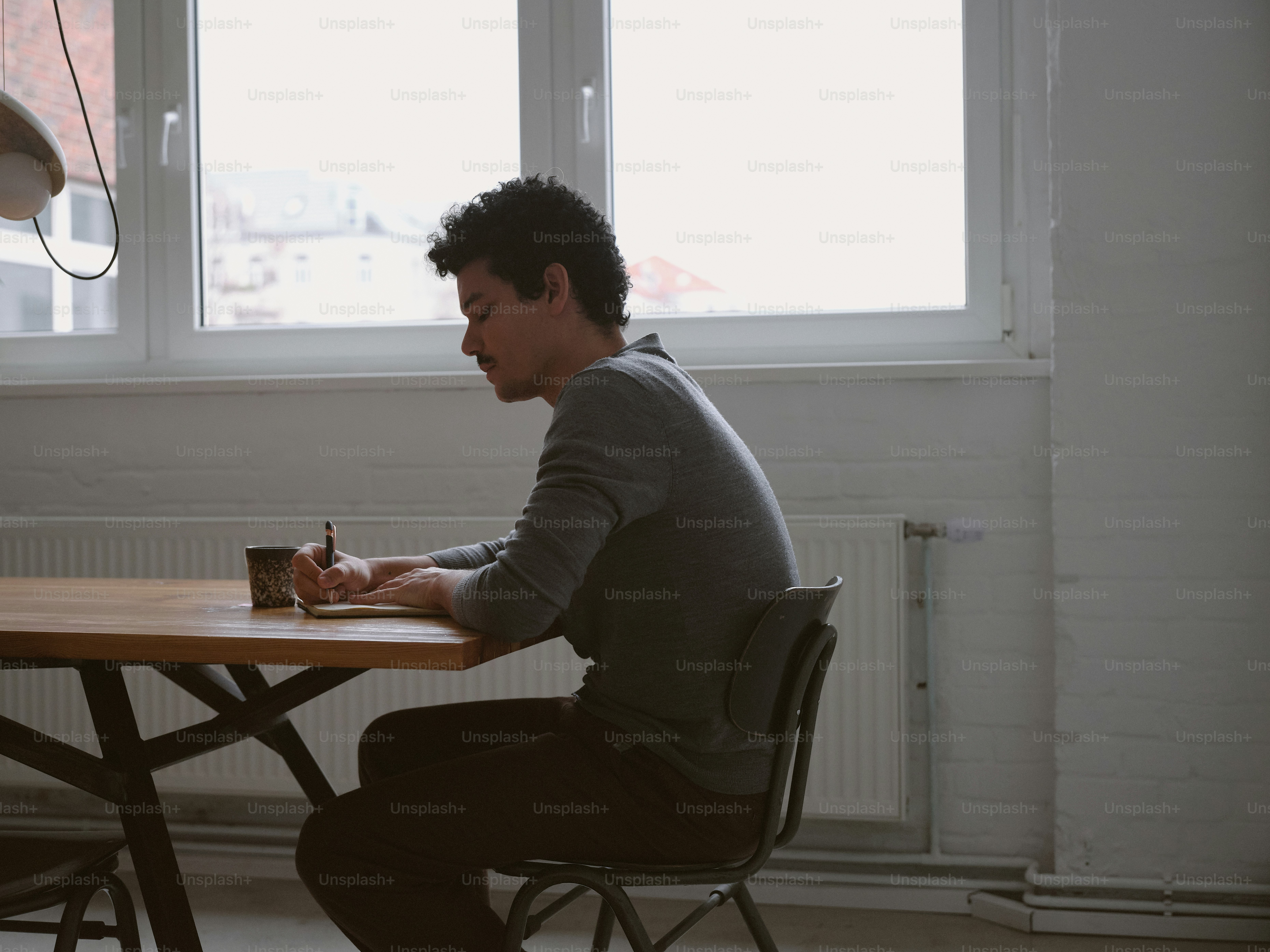 A man sitting at a table in front of a window