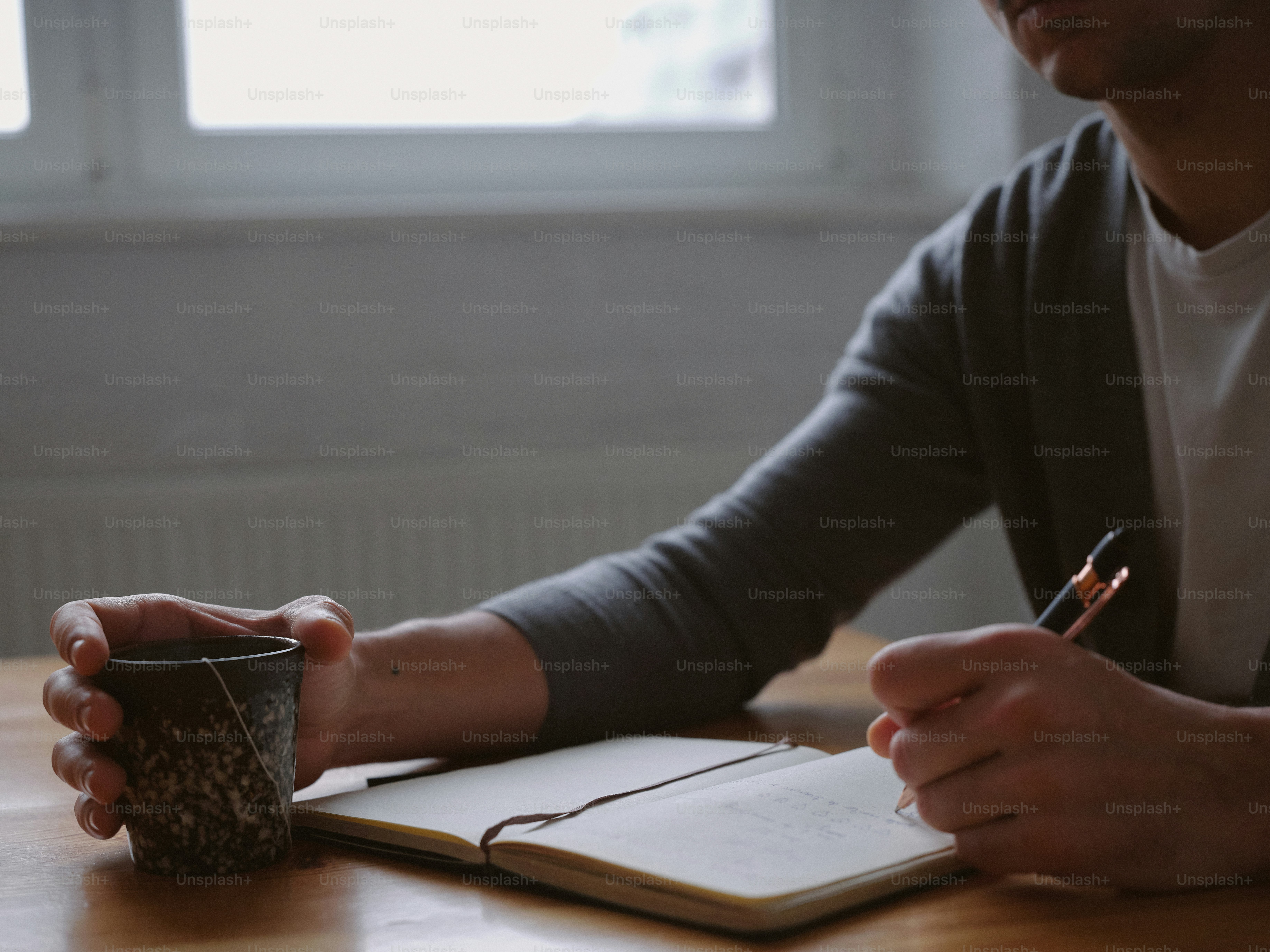 Seorang pria duduk di meja menulis di buku catatan