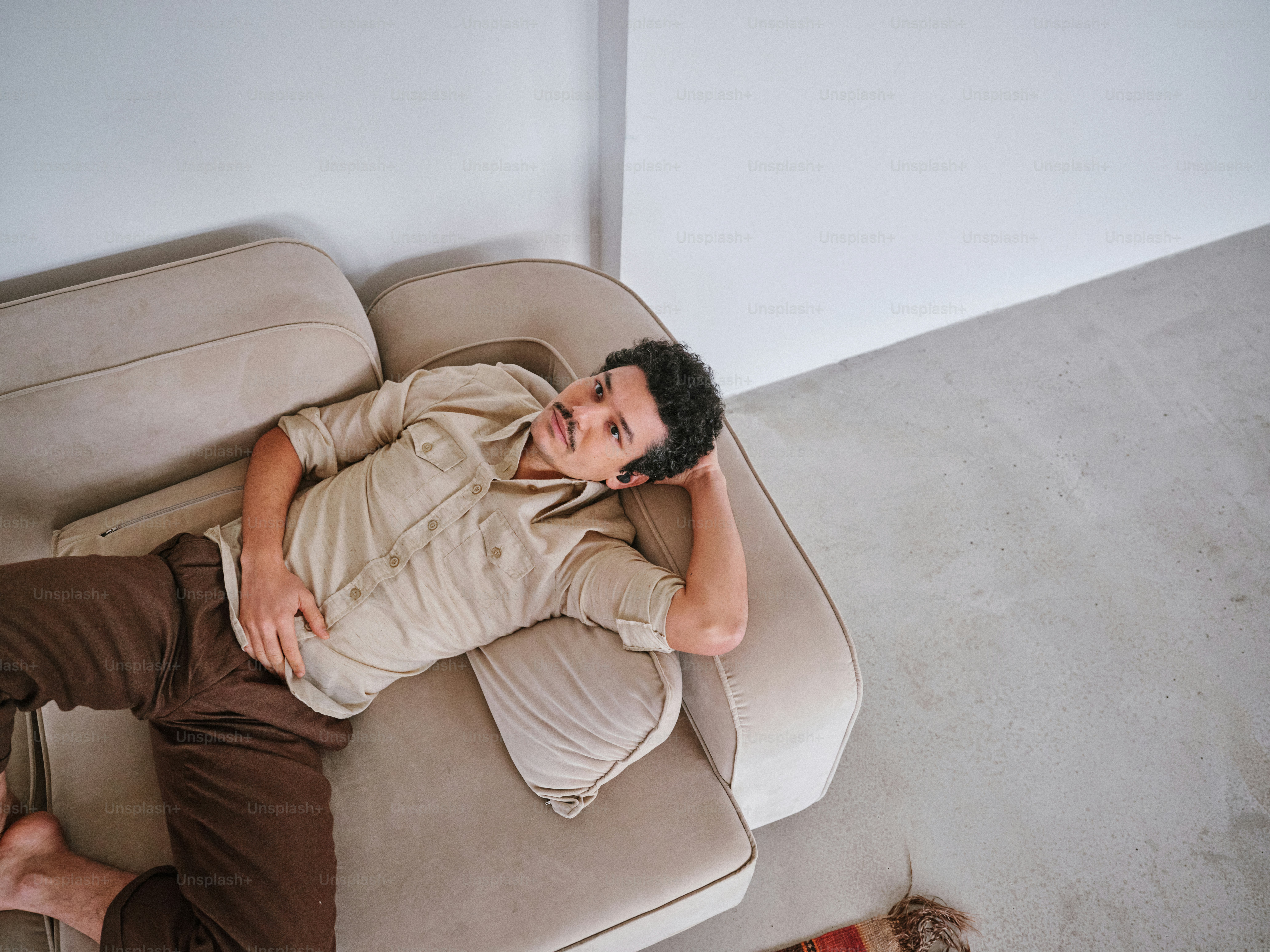 A man laying on top of a couch next to a dog