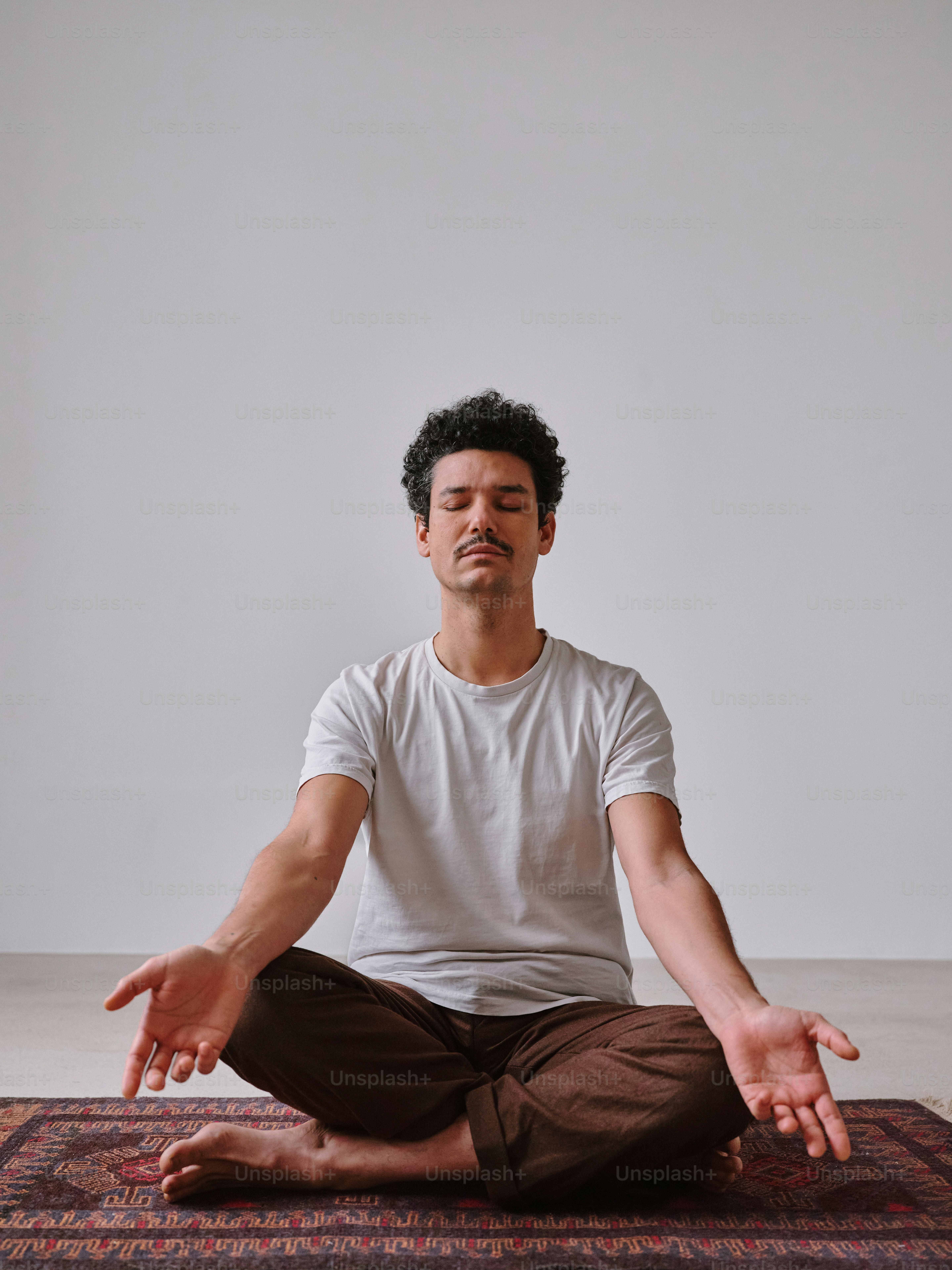 Un homme assis en position de yoga sur un tapis