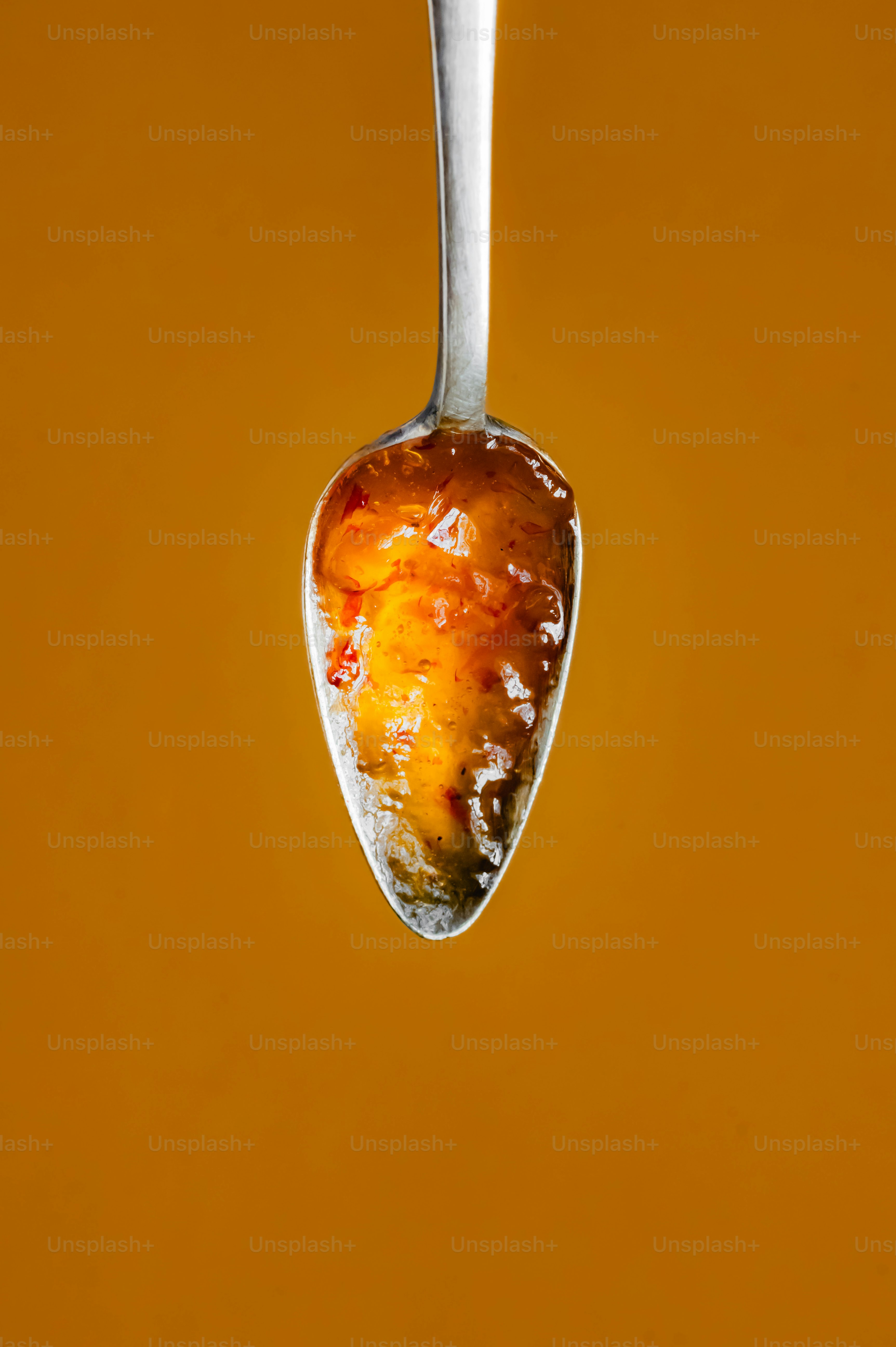 A spoon with a liquid drop hanging from it