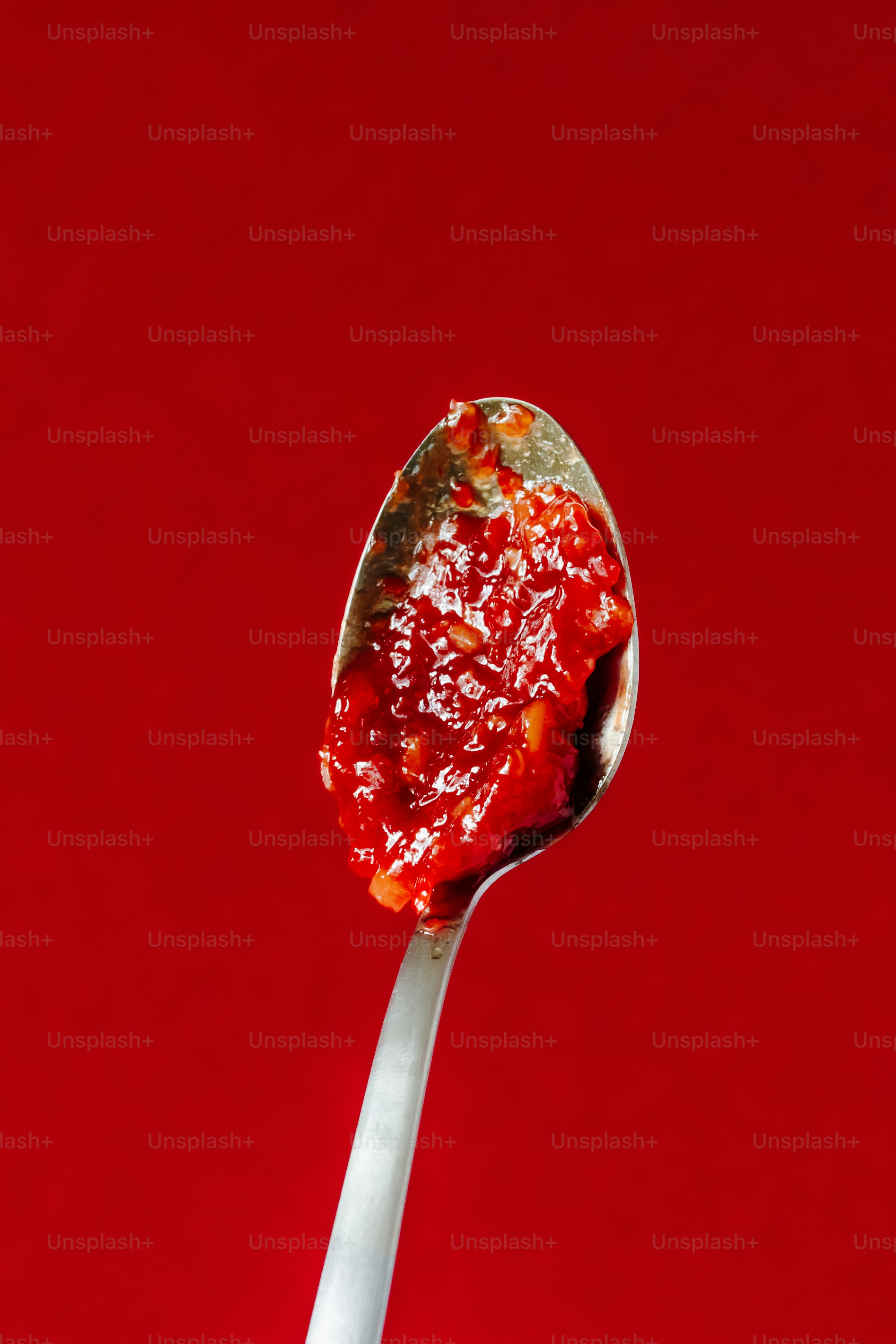 Un cucchiaio pieno di cibo seduto sopra un tavolo rosso