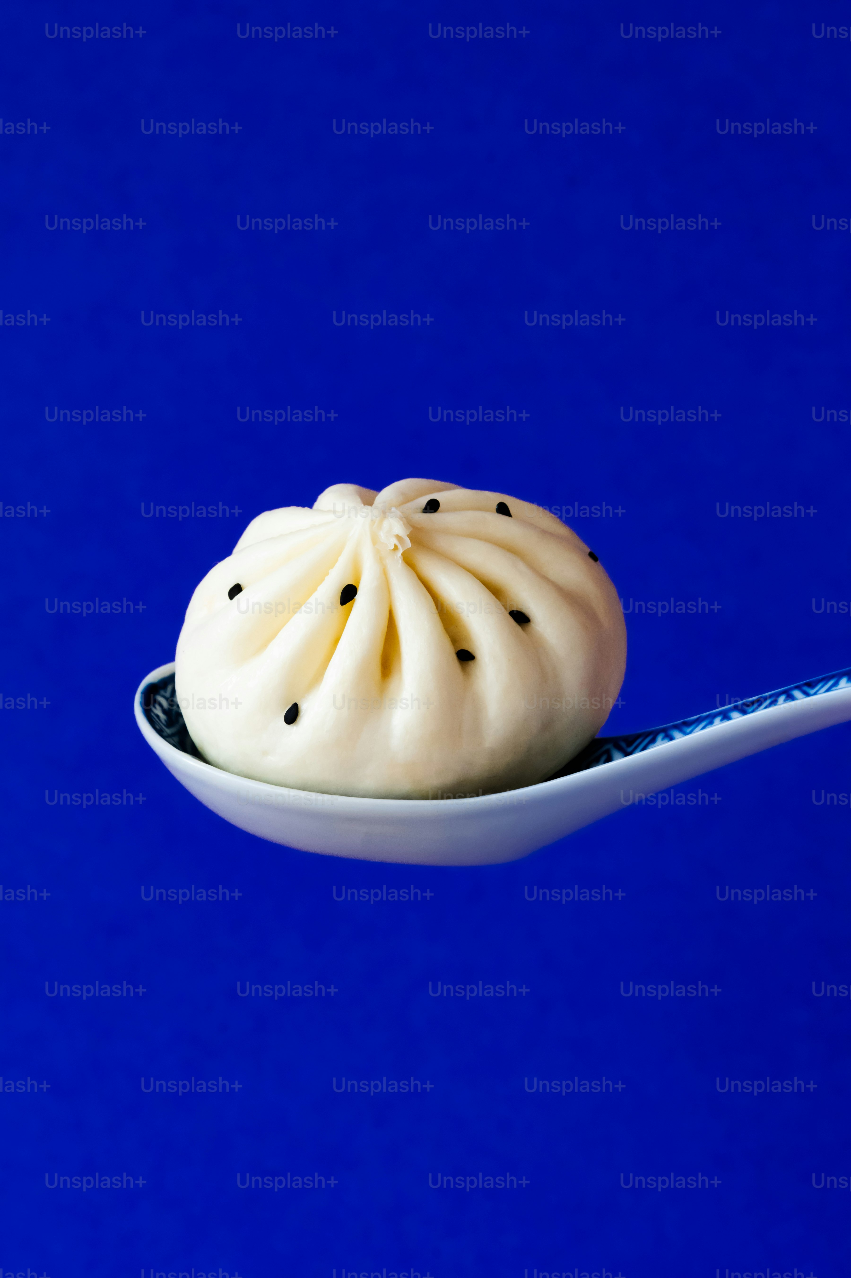 A spoon with a small white pastry on it