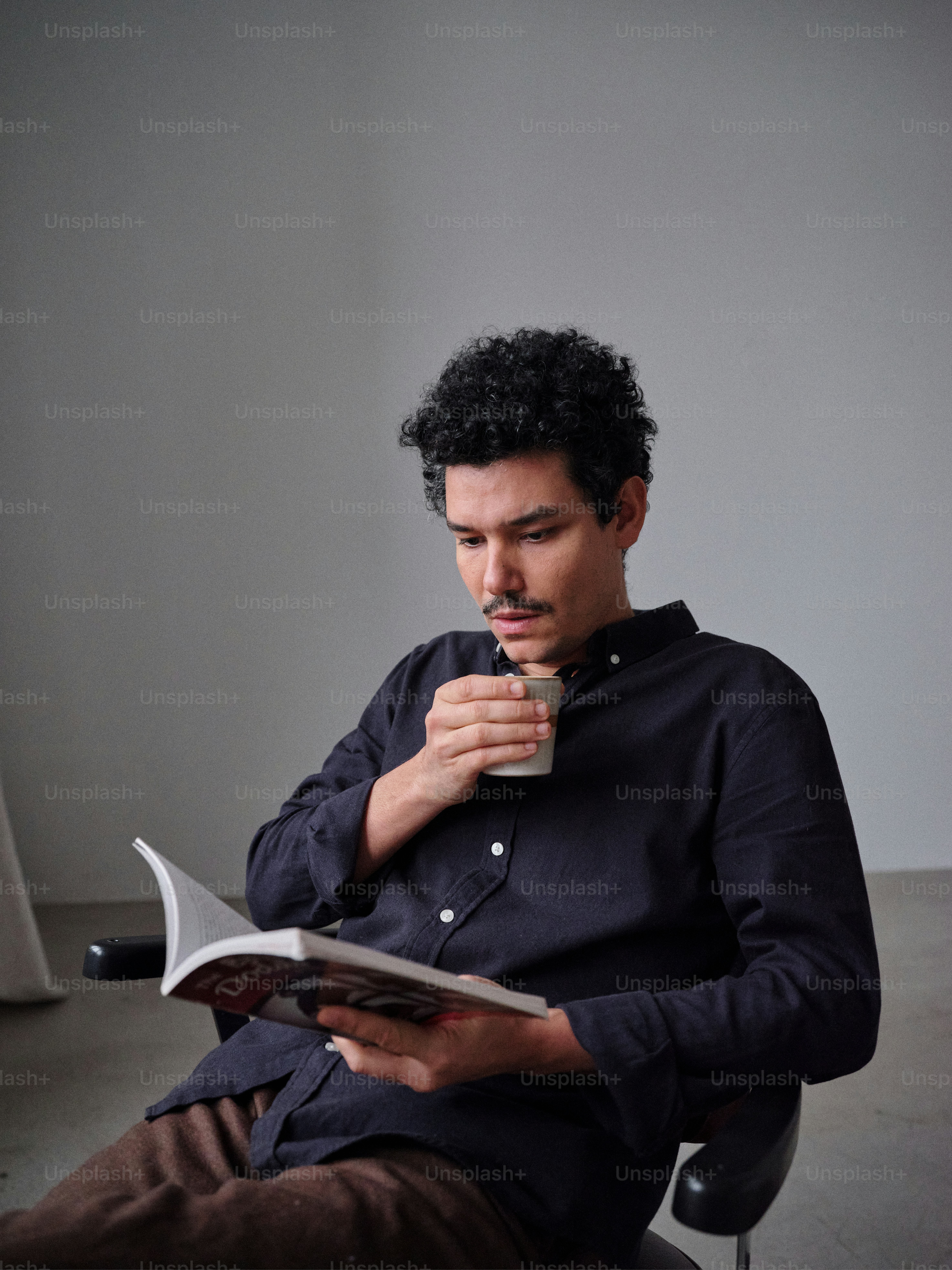 A man sitting on a chair reading a book