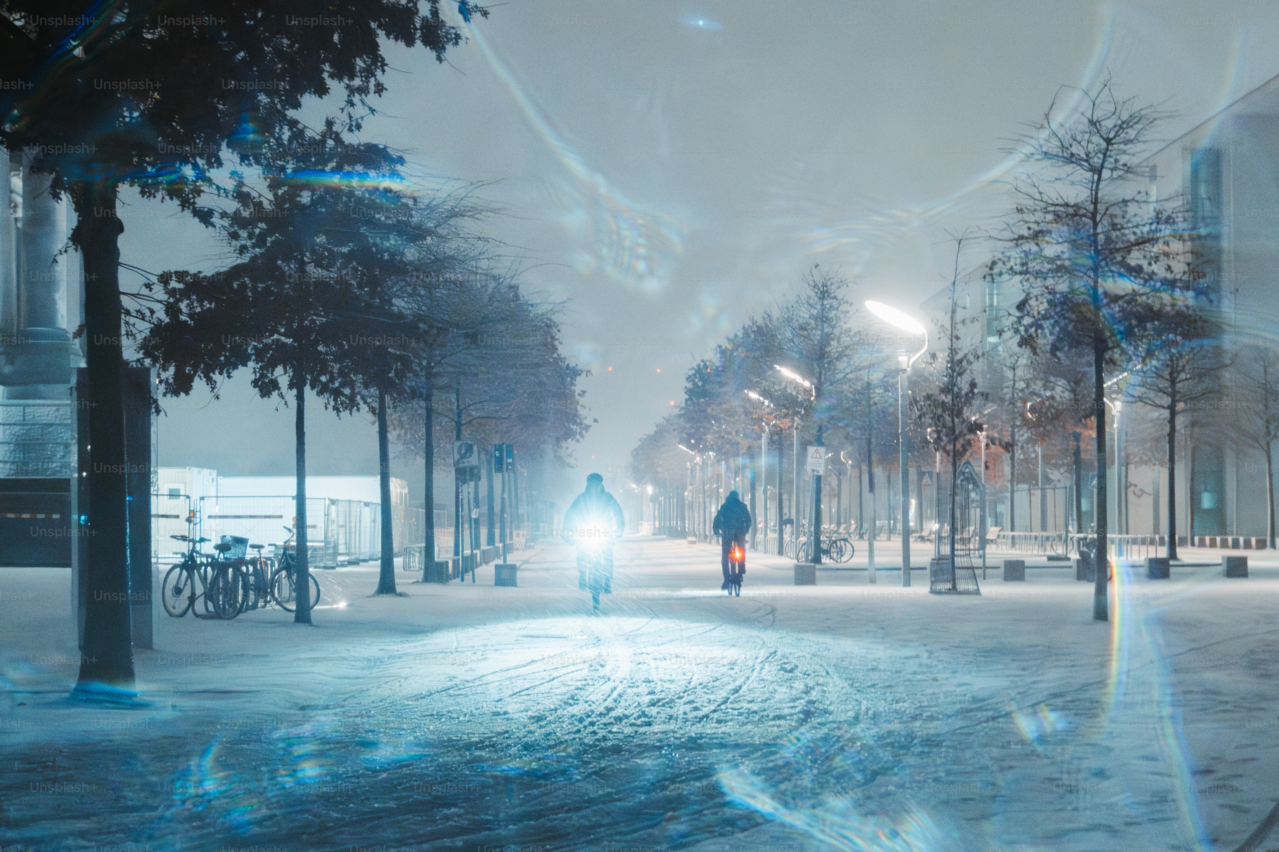 A person walking down a snowy street at night