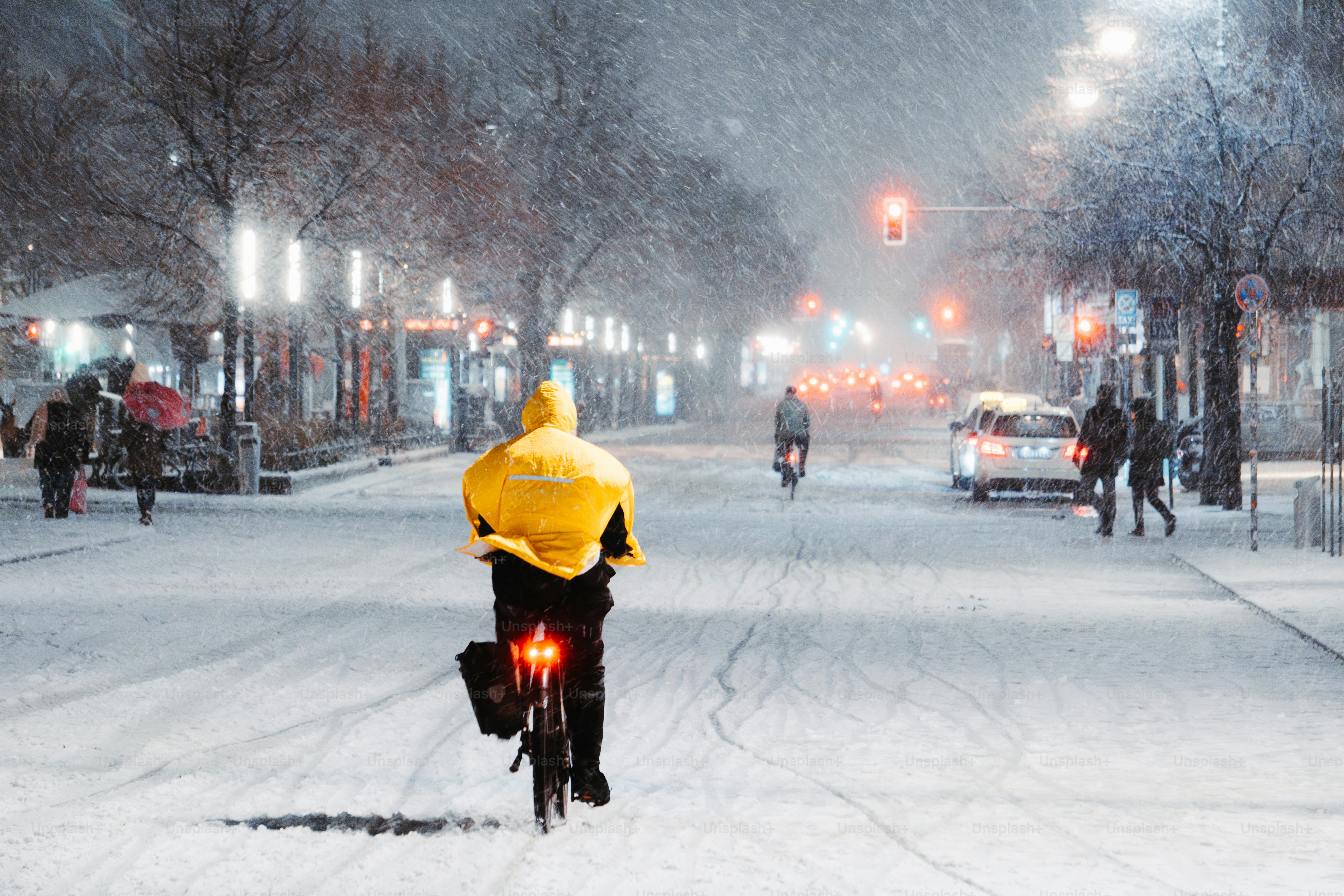 A man riding a bike down a snow covered street