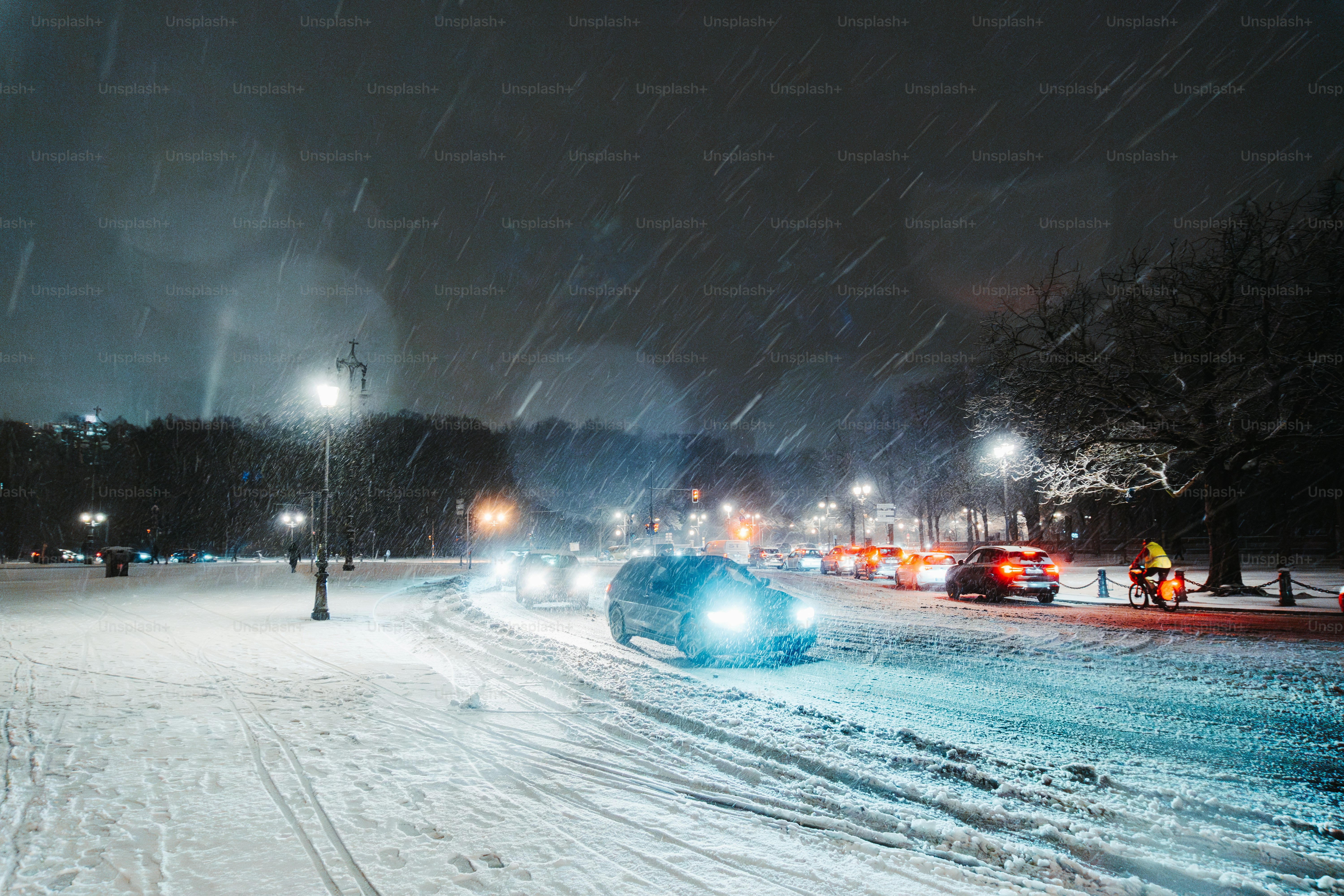 A car driving down a snow covered road at night