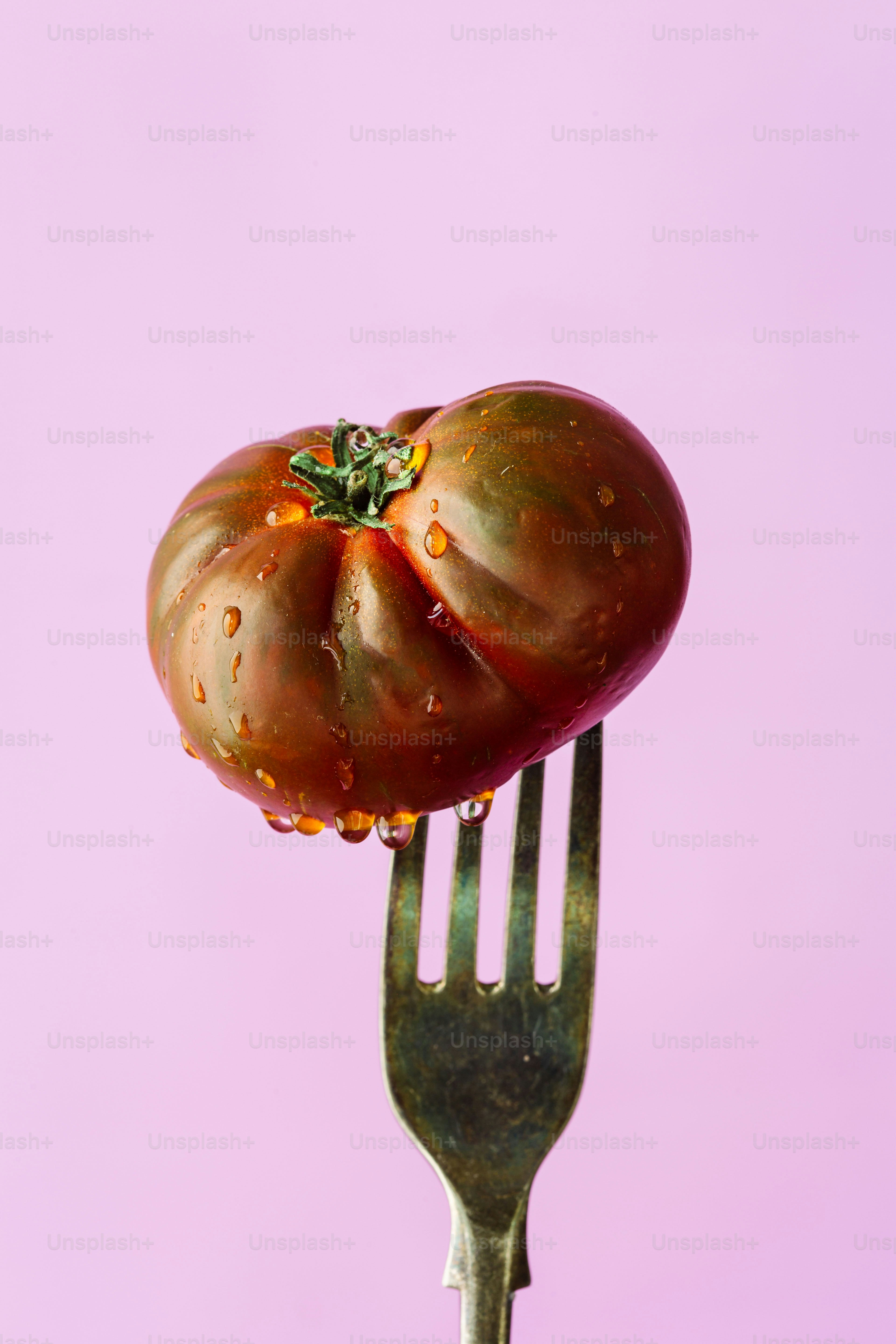 A fork with a tomato on top of it