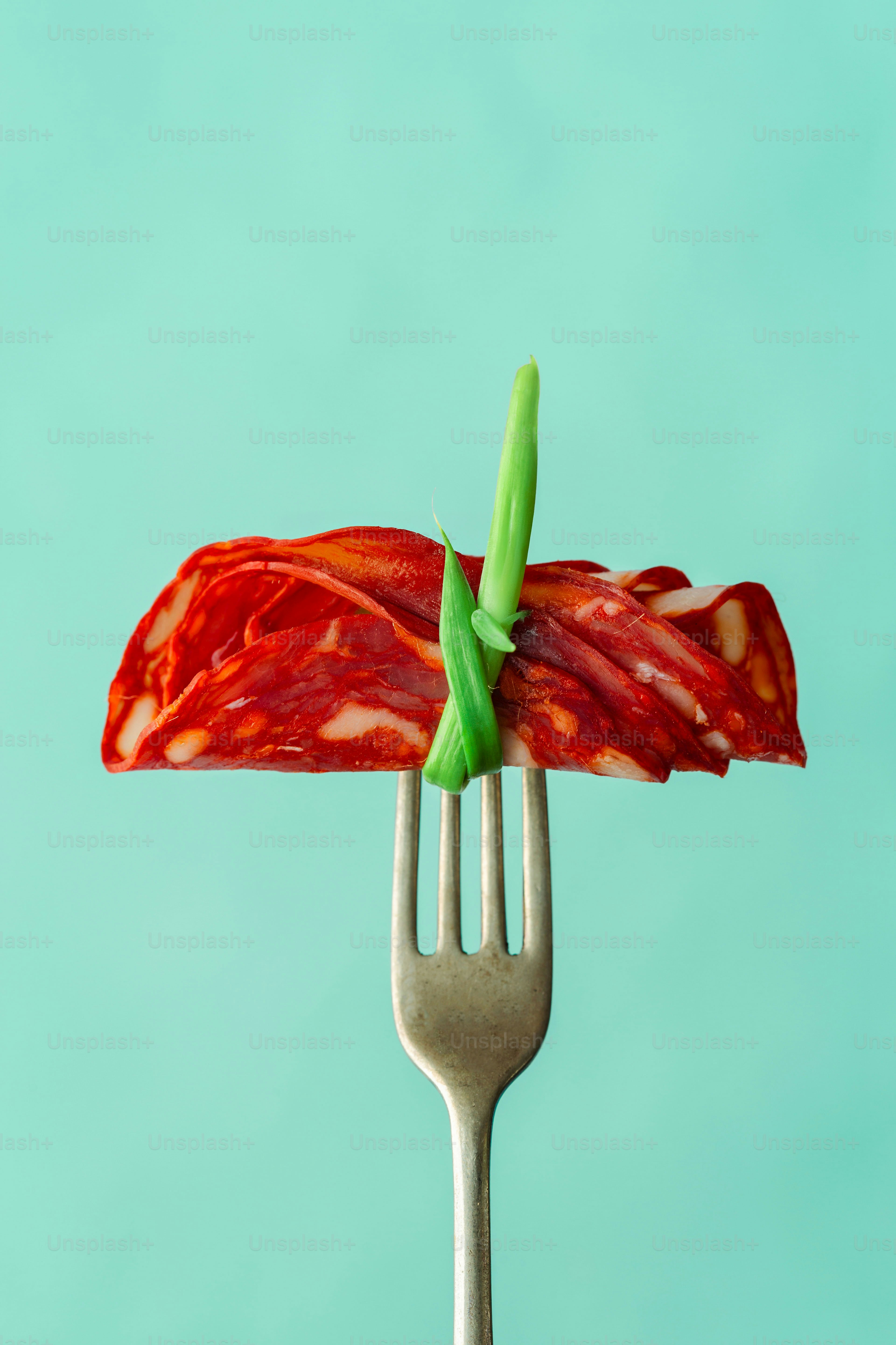 A fork with a piece of bacon on top of it