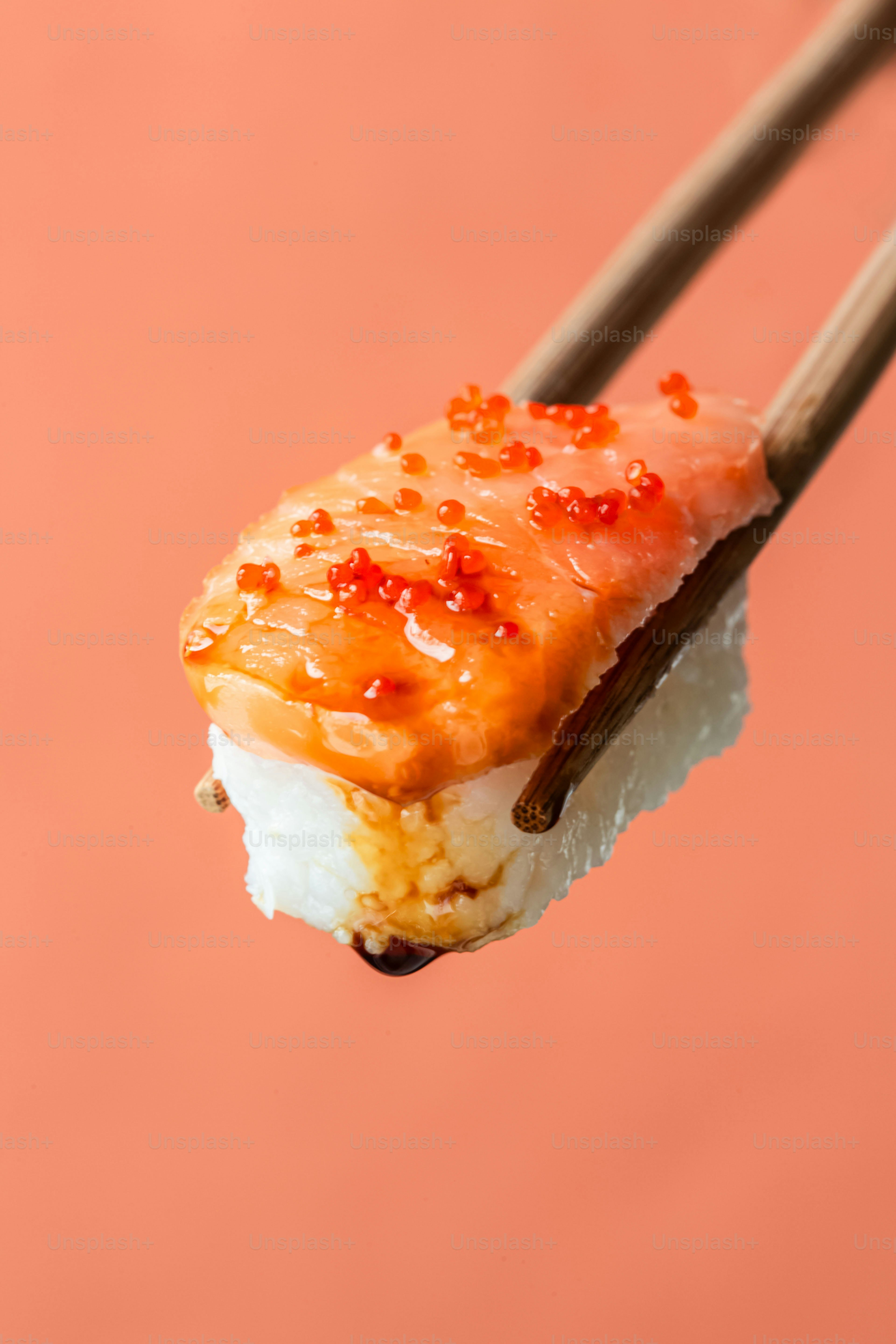 A piece of sushi with chopsticks sticking out of it
