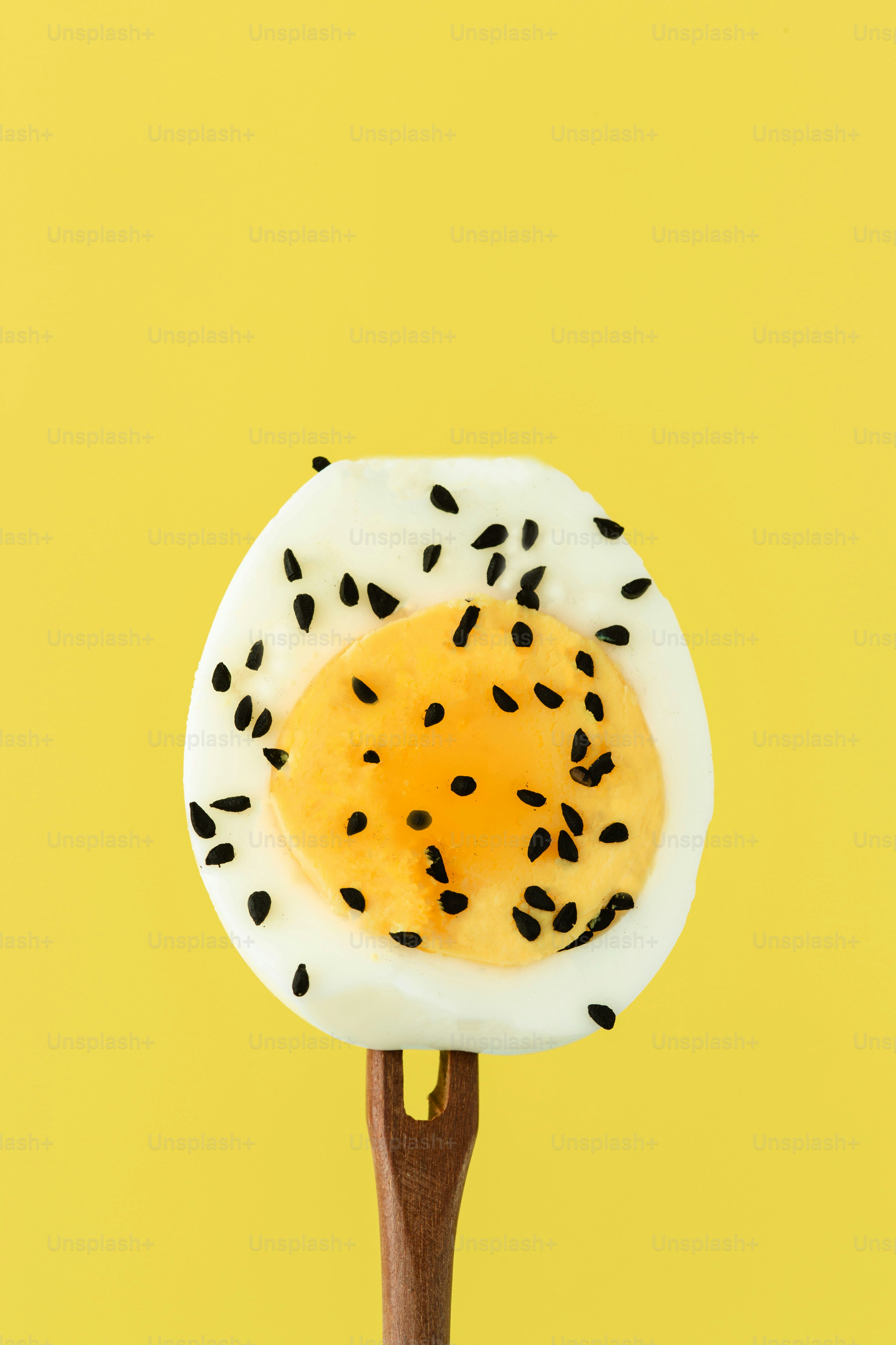 An egg on a stick on a yellow background