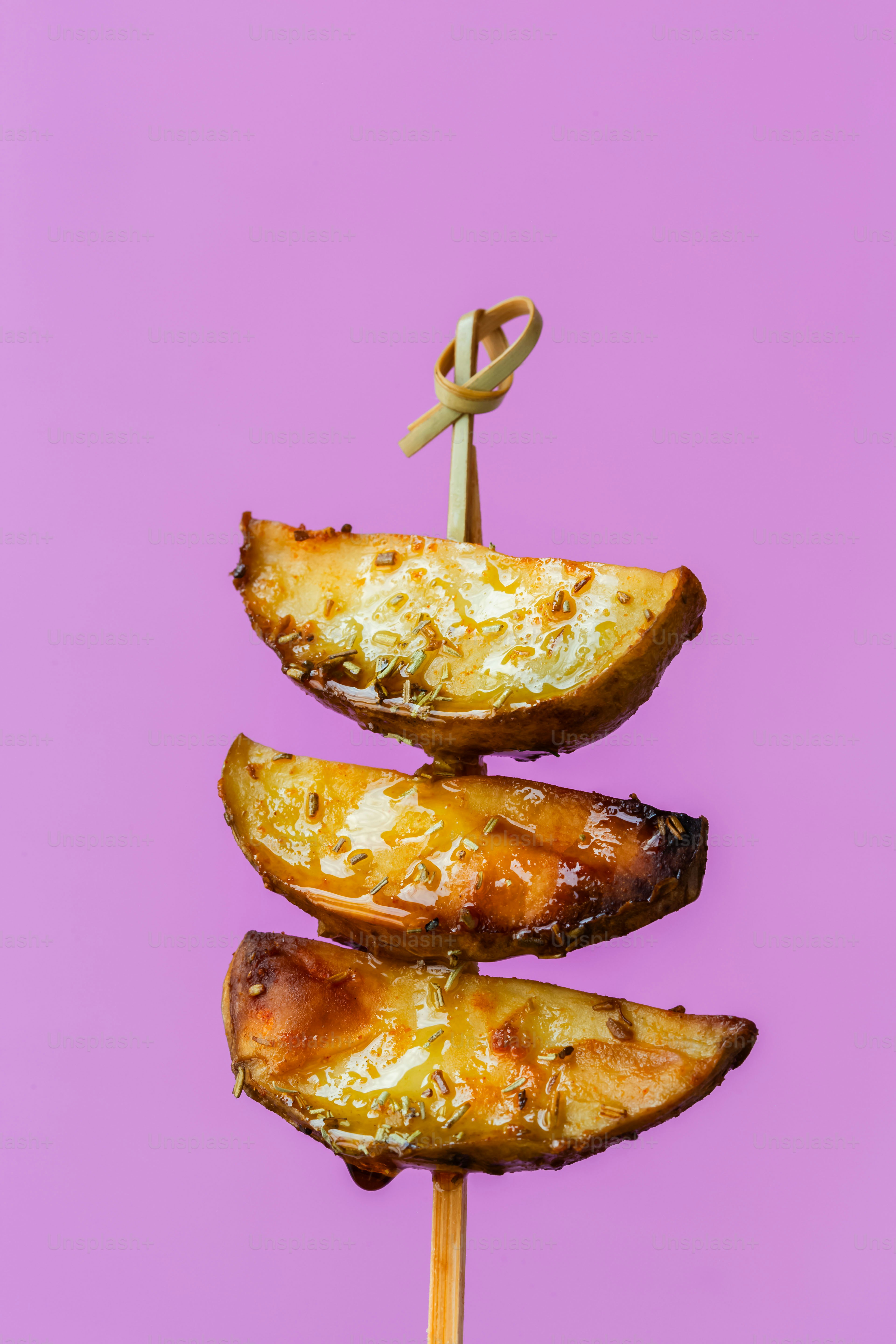 A skewer of food on a stick on a purple background