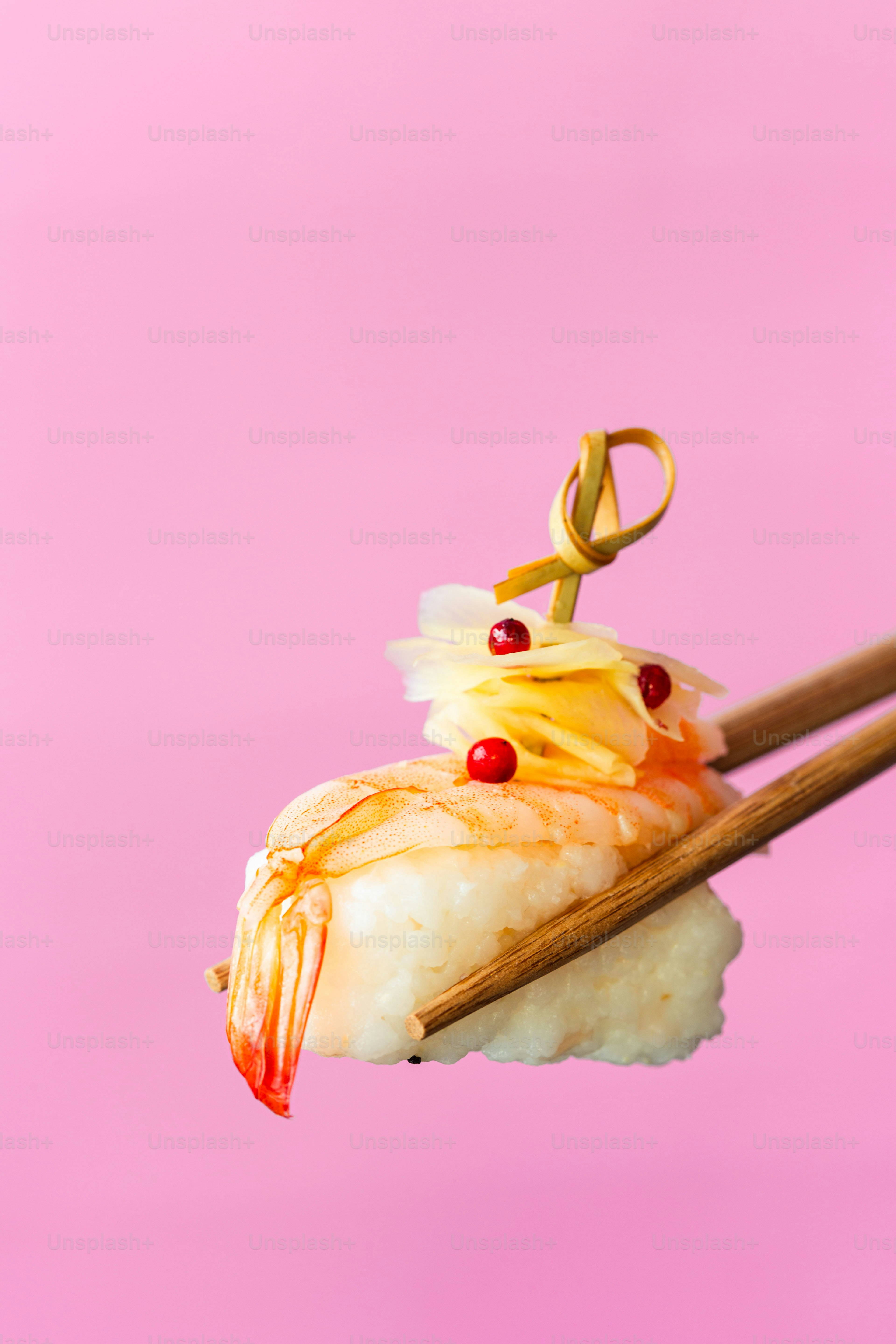 A piece of sushi with chopsticks sticking out of it