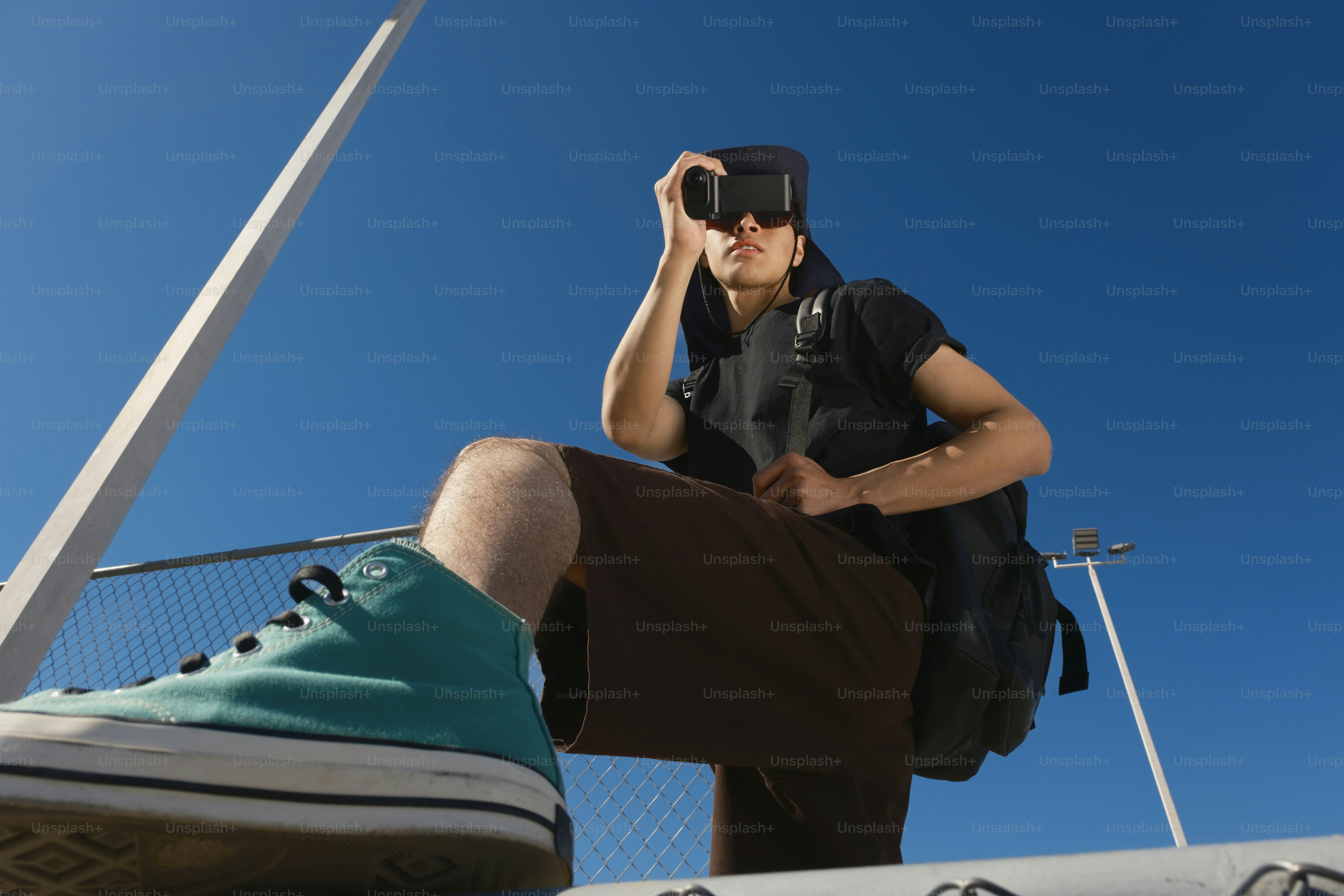 A man sitting on top of a boat while holding a camera