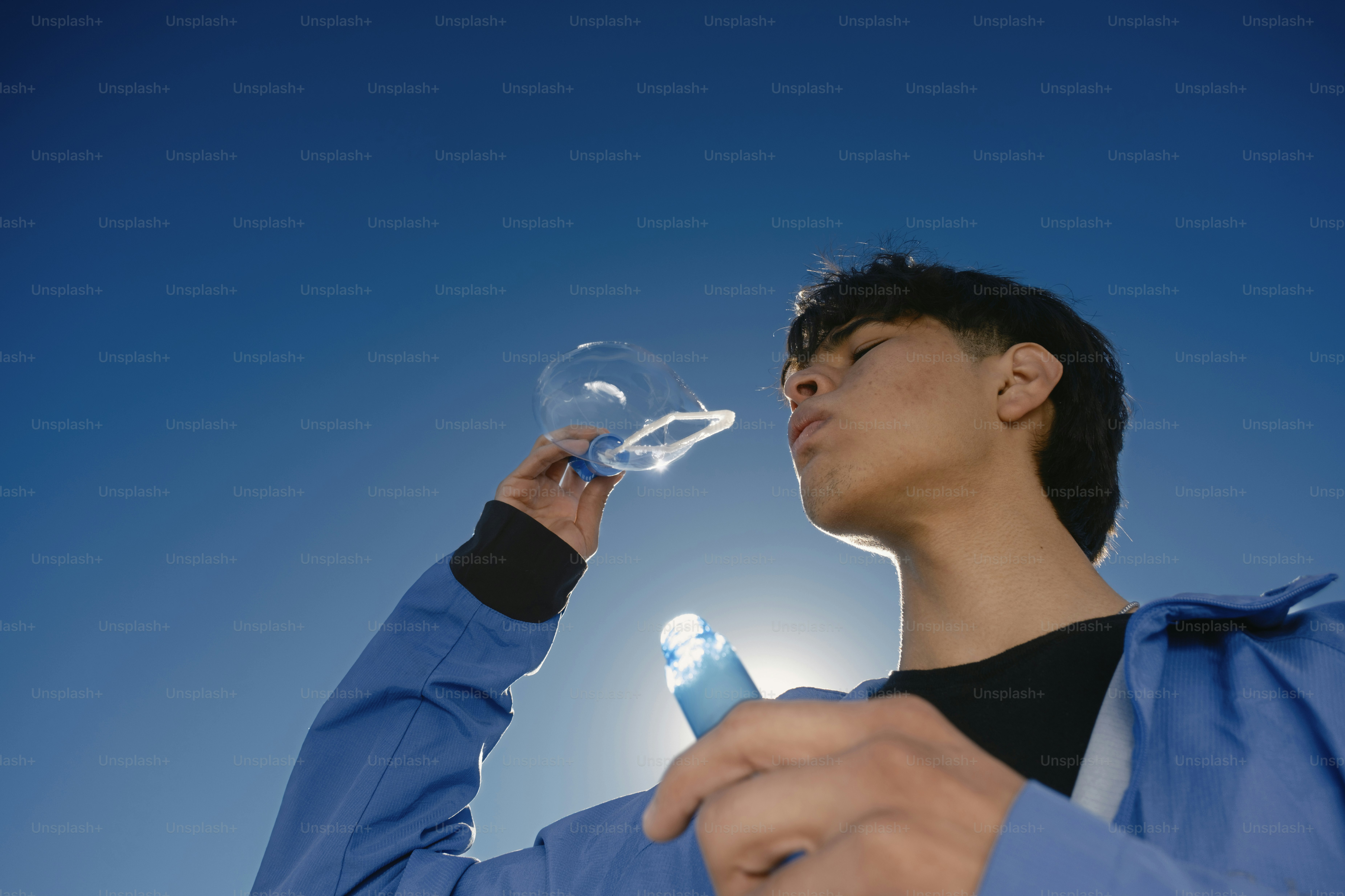 A man in a blue jacket holding a cell phone