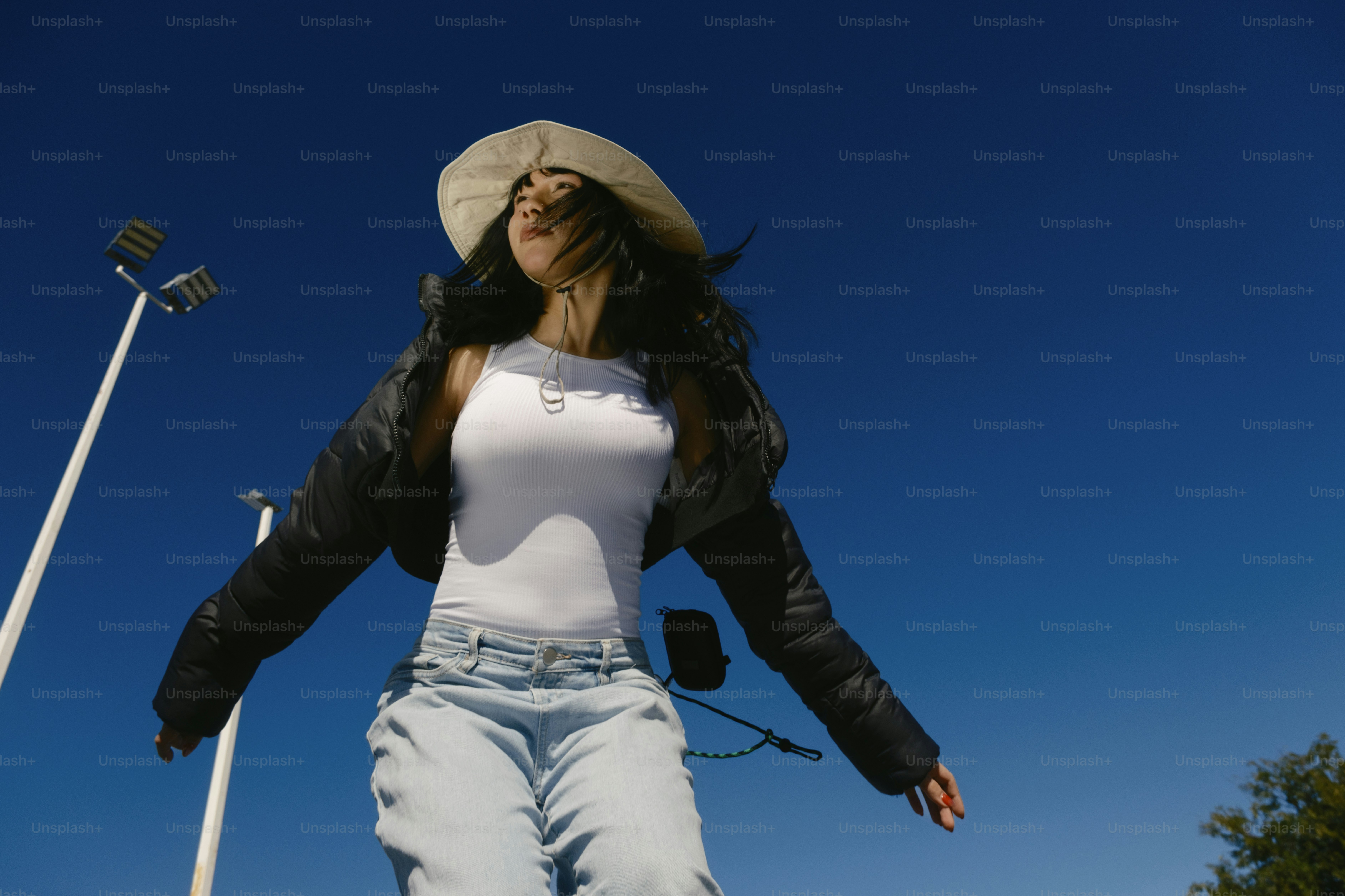 A woman in white shirt and jeans on a skateboard