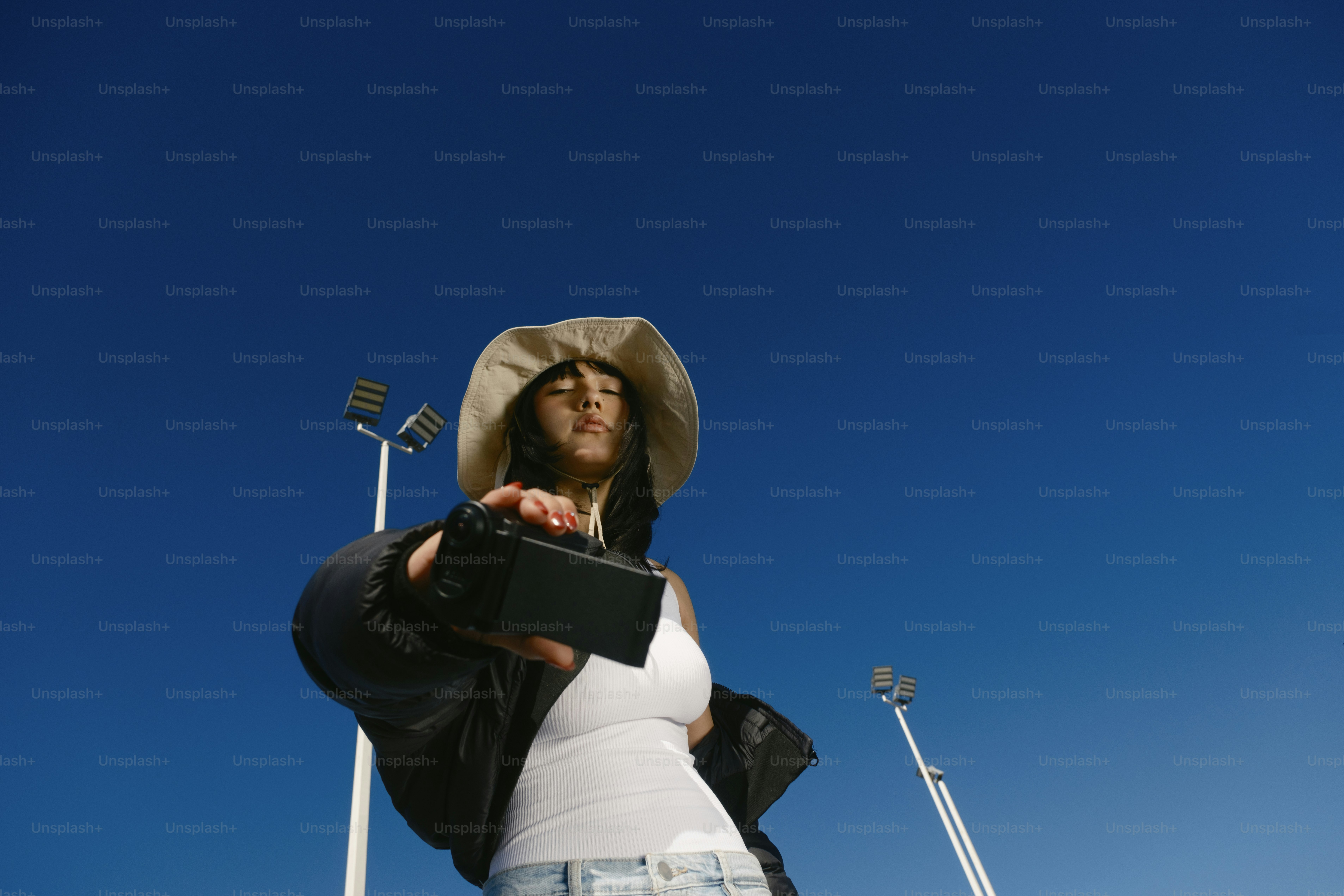 A woman wearing a hat and holding a camera