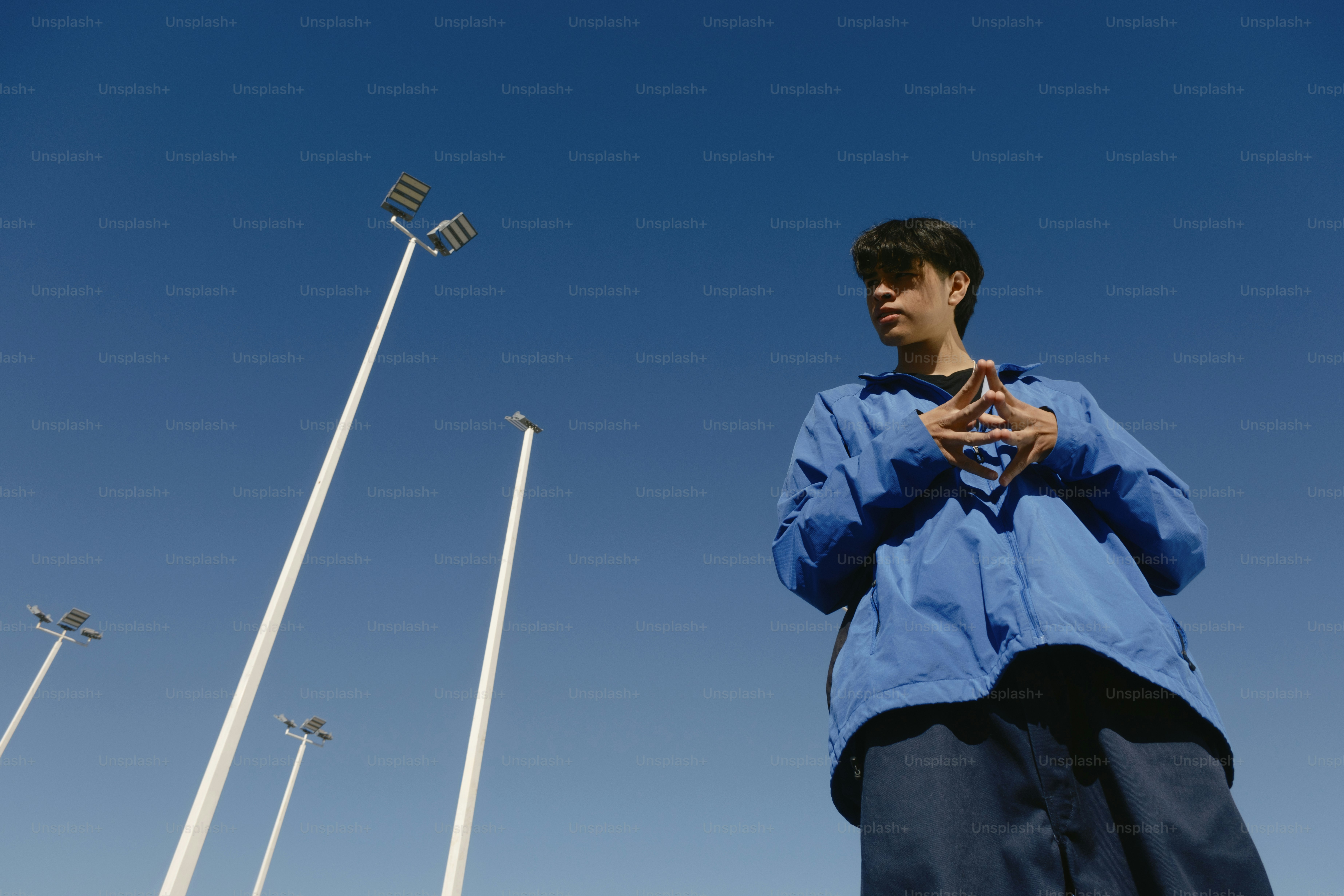 A man standing in front of a blue sky looking at his cell phone