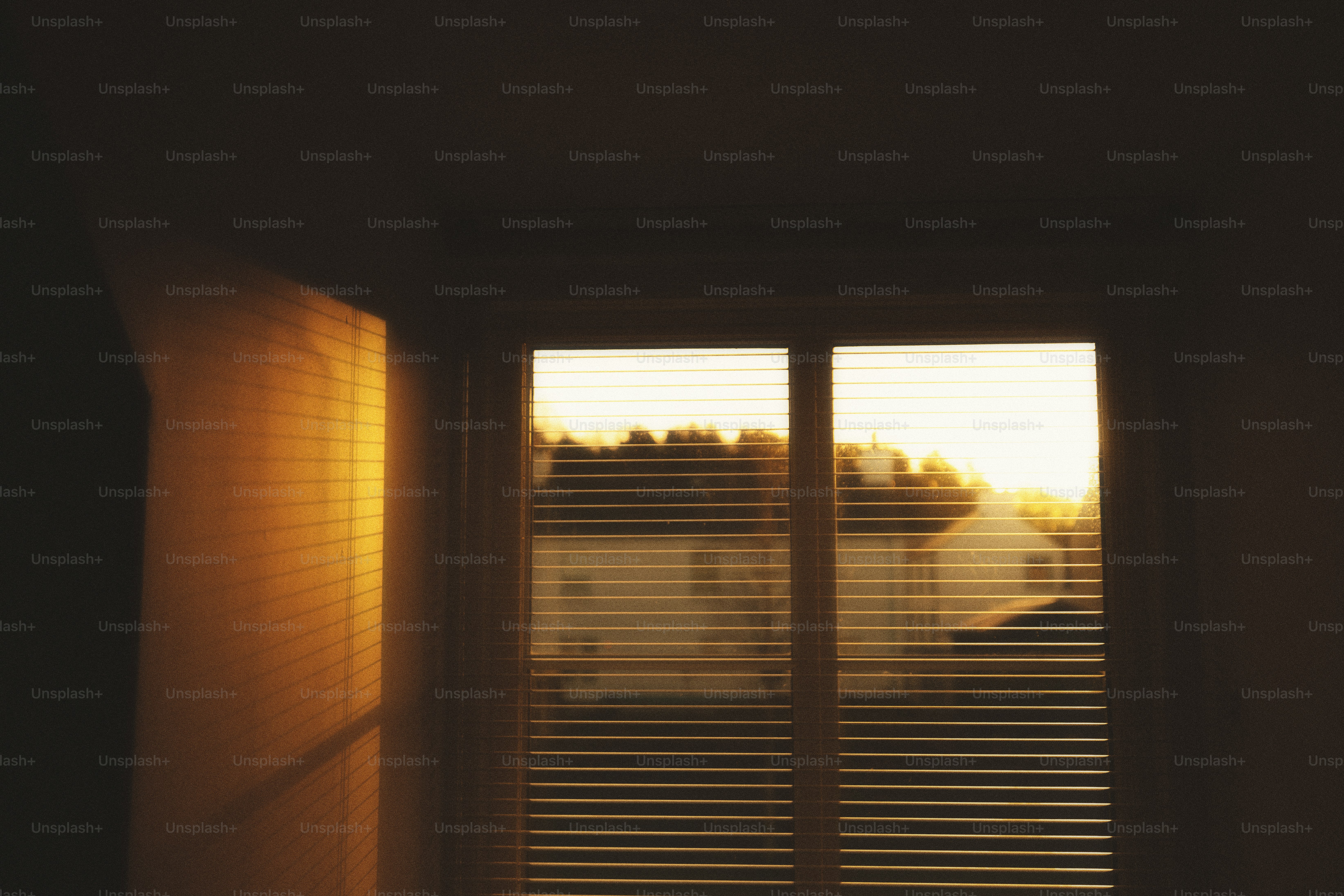 A bedroom with a bed and a window with blinds