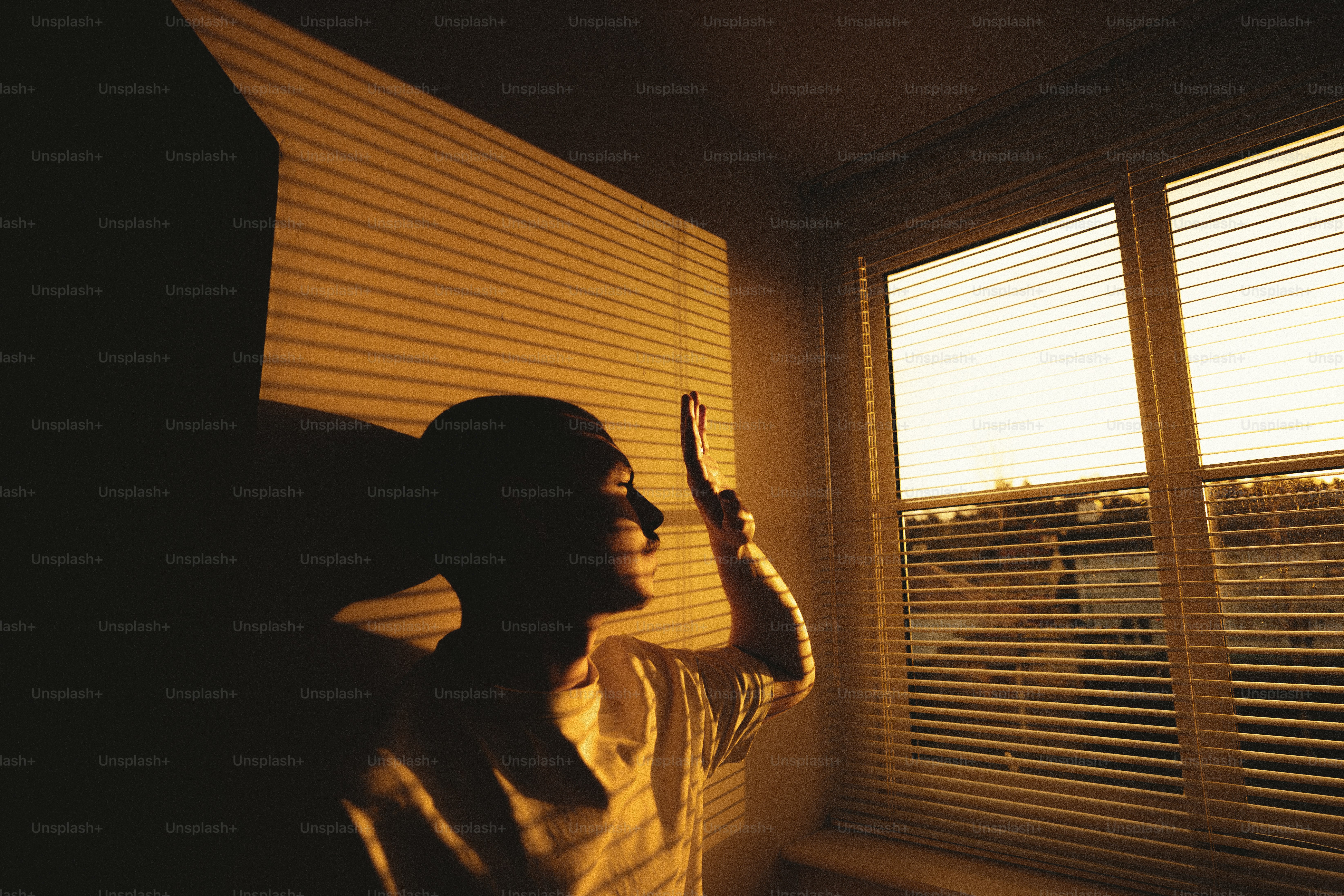A person standing in front of a window holding a cell phone