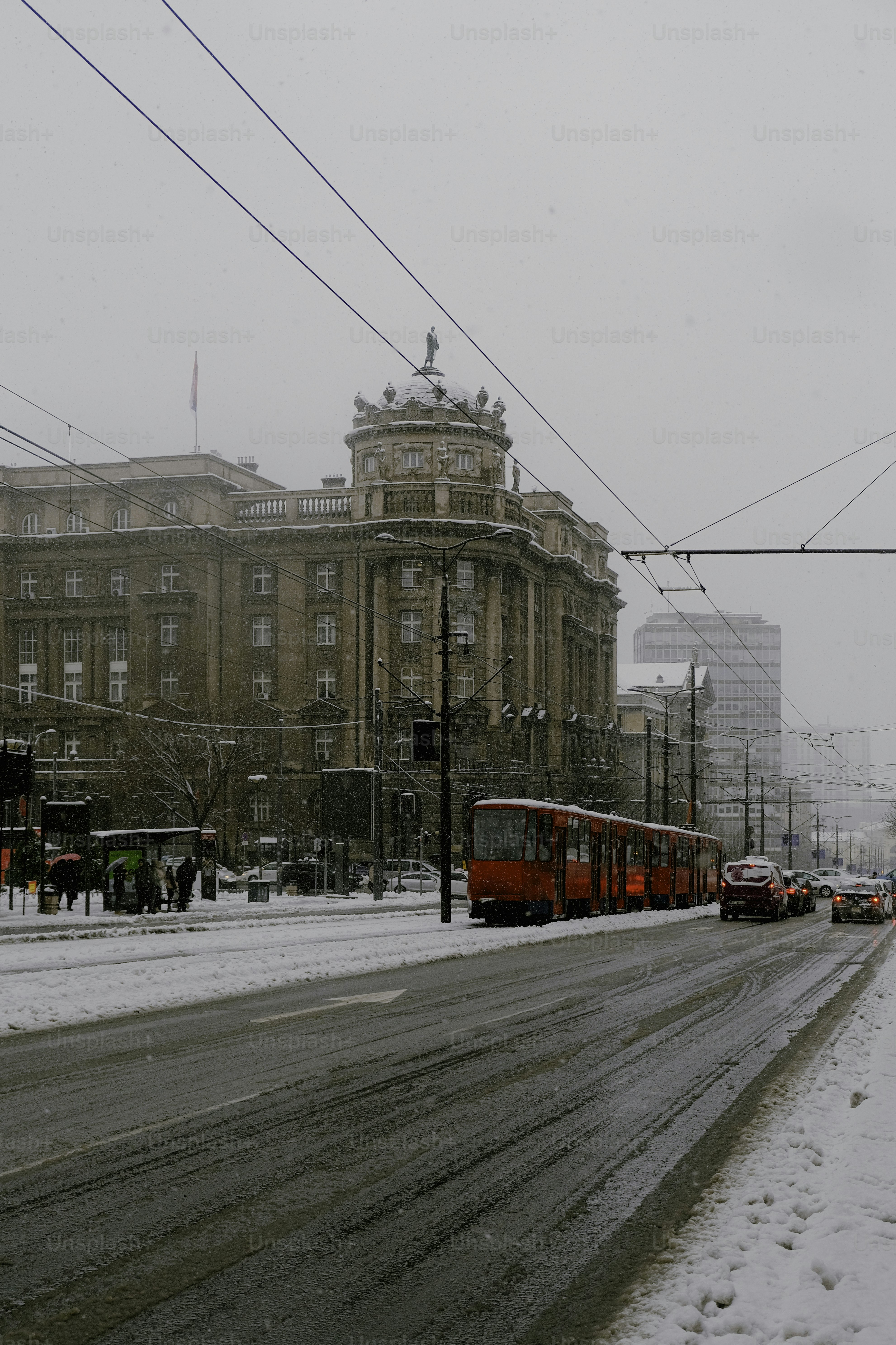 A red train traveling down a snow covered street