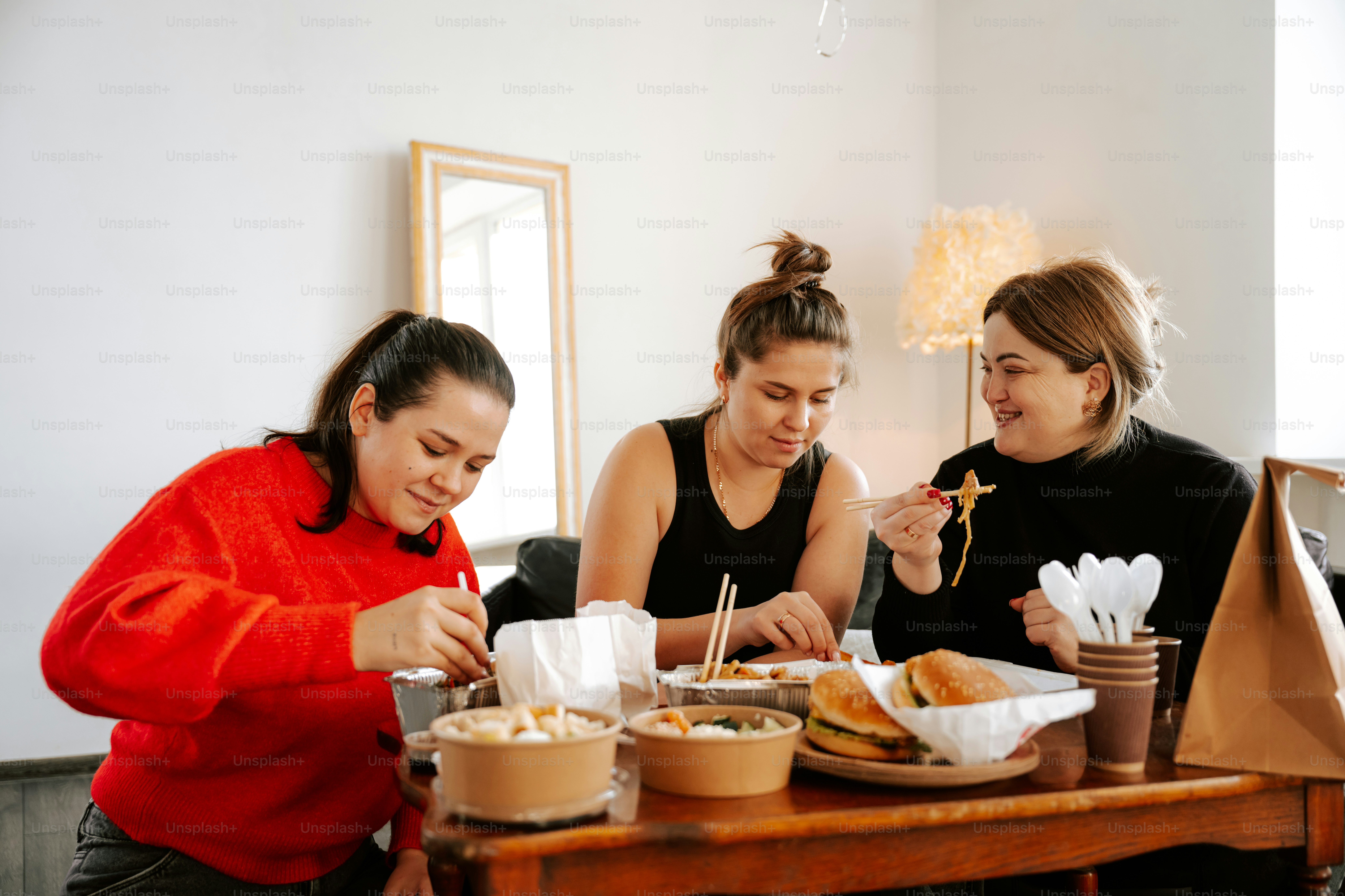 A group of women sitting around a table eating food