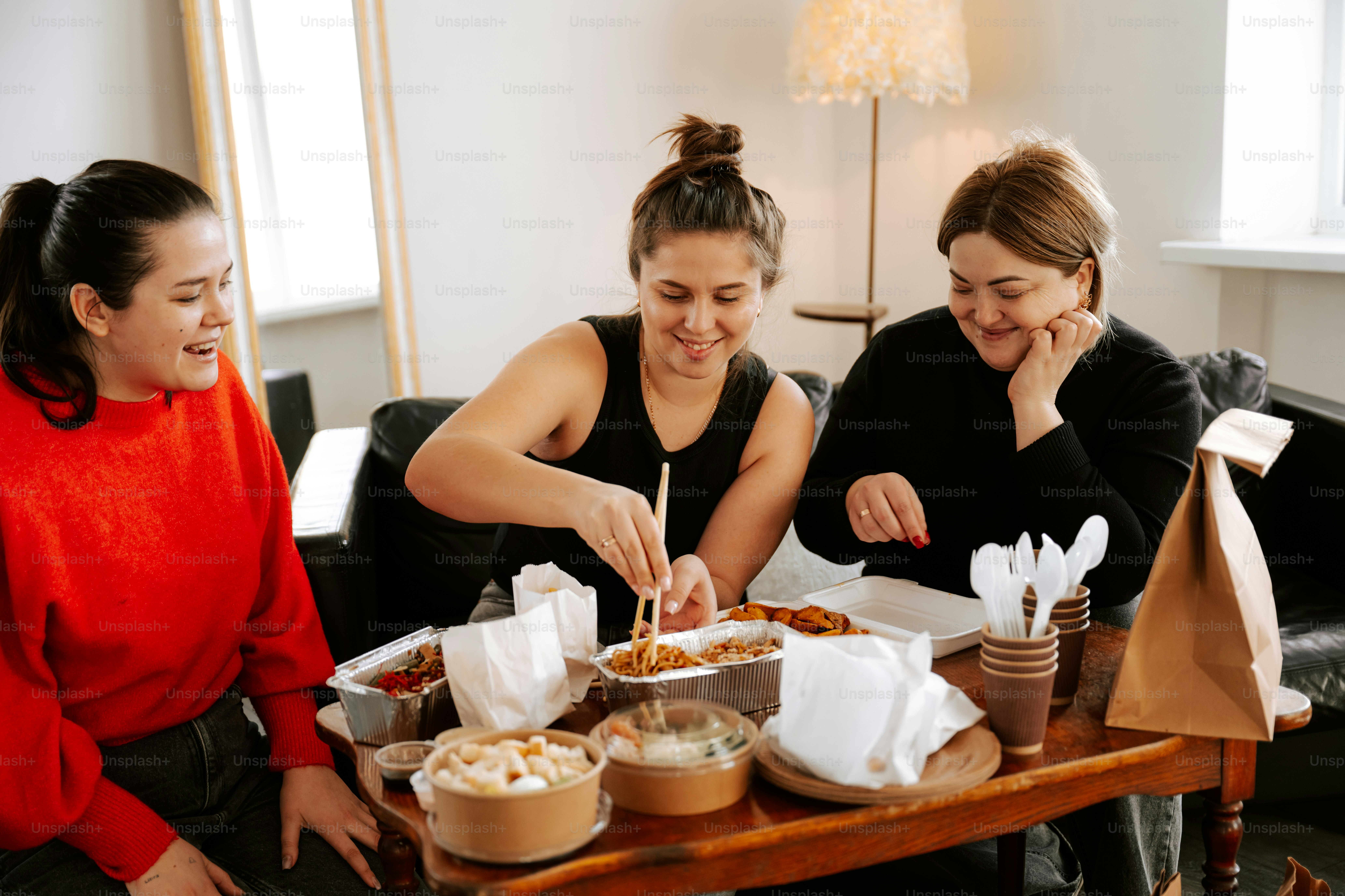 A group of women sitting around a table eating food