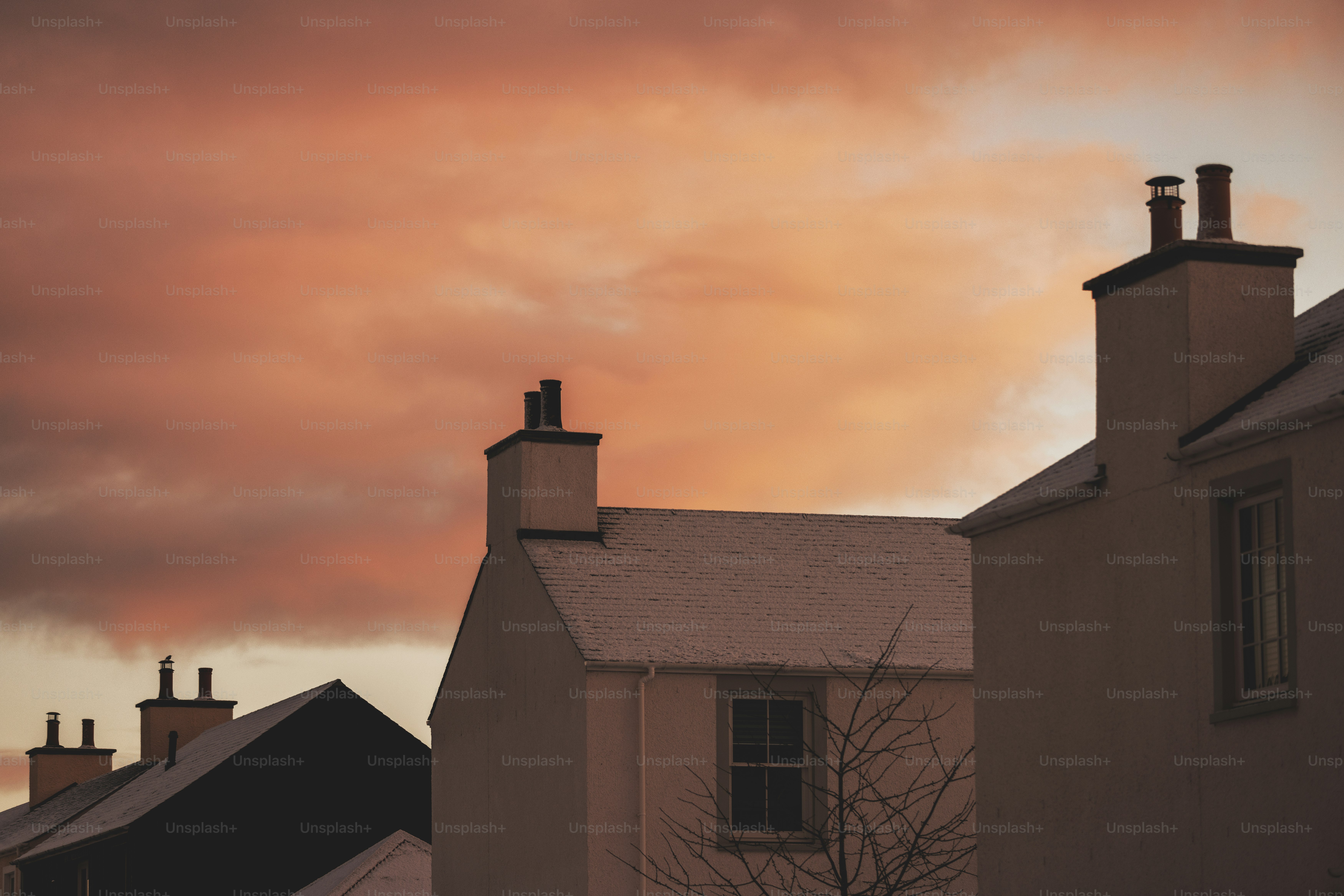 A red sky is seen over a row of houses