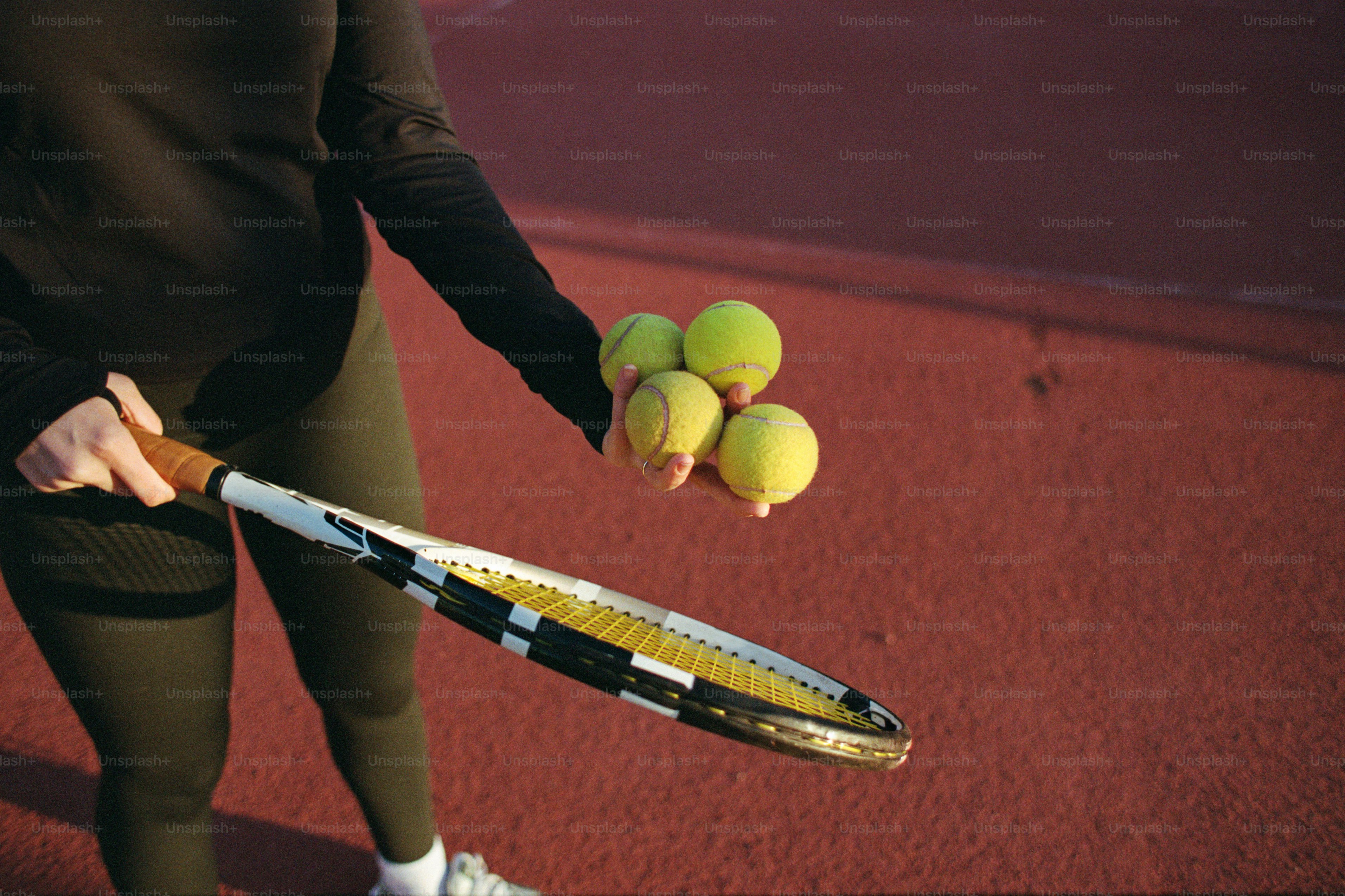 A person holding a tennis racket and tennis balls photo – Sports Image ...