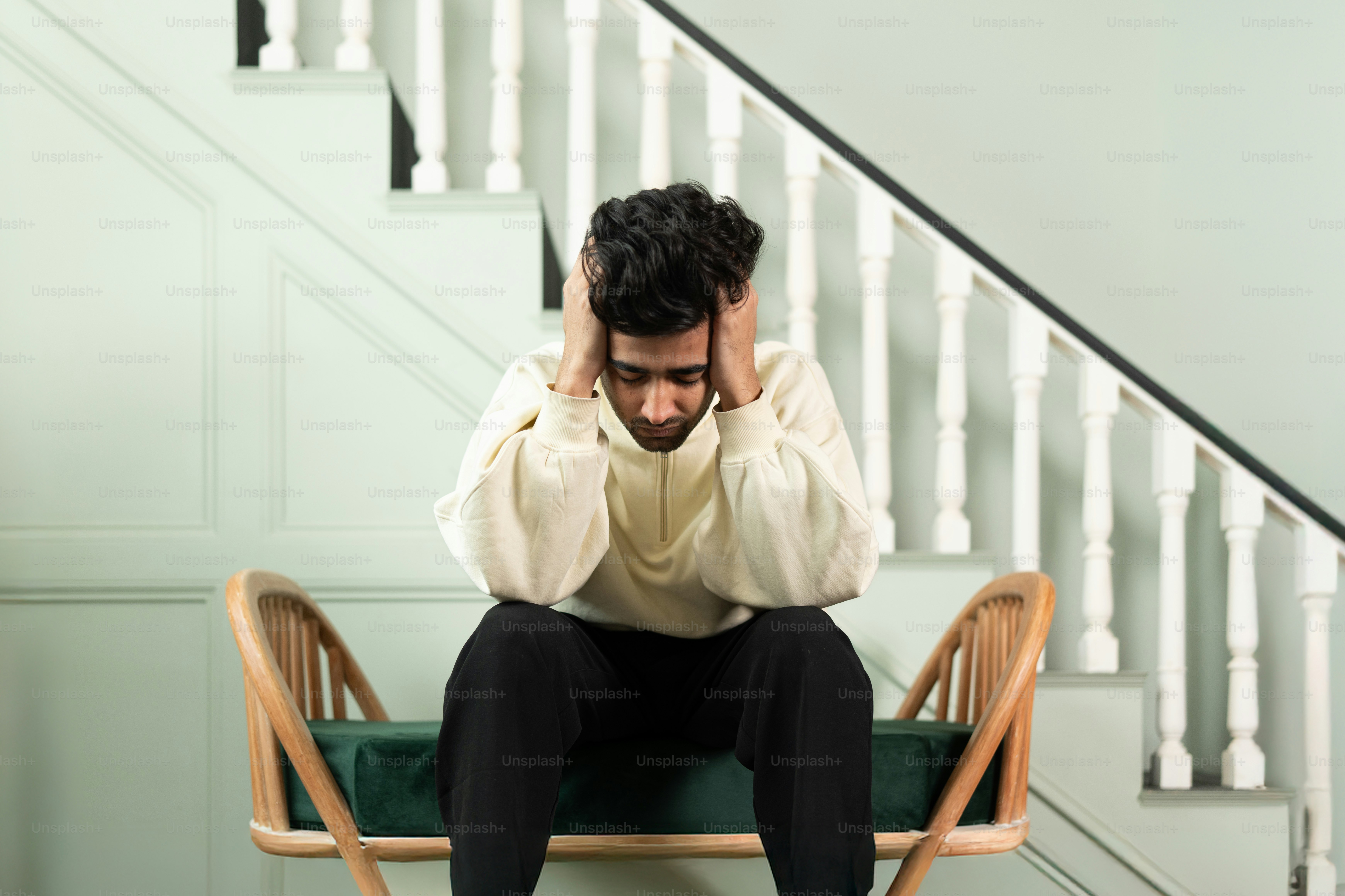 A man sitting on a bench in front of a stair case