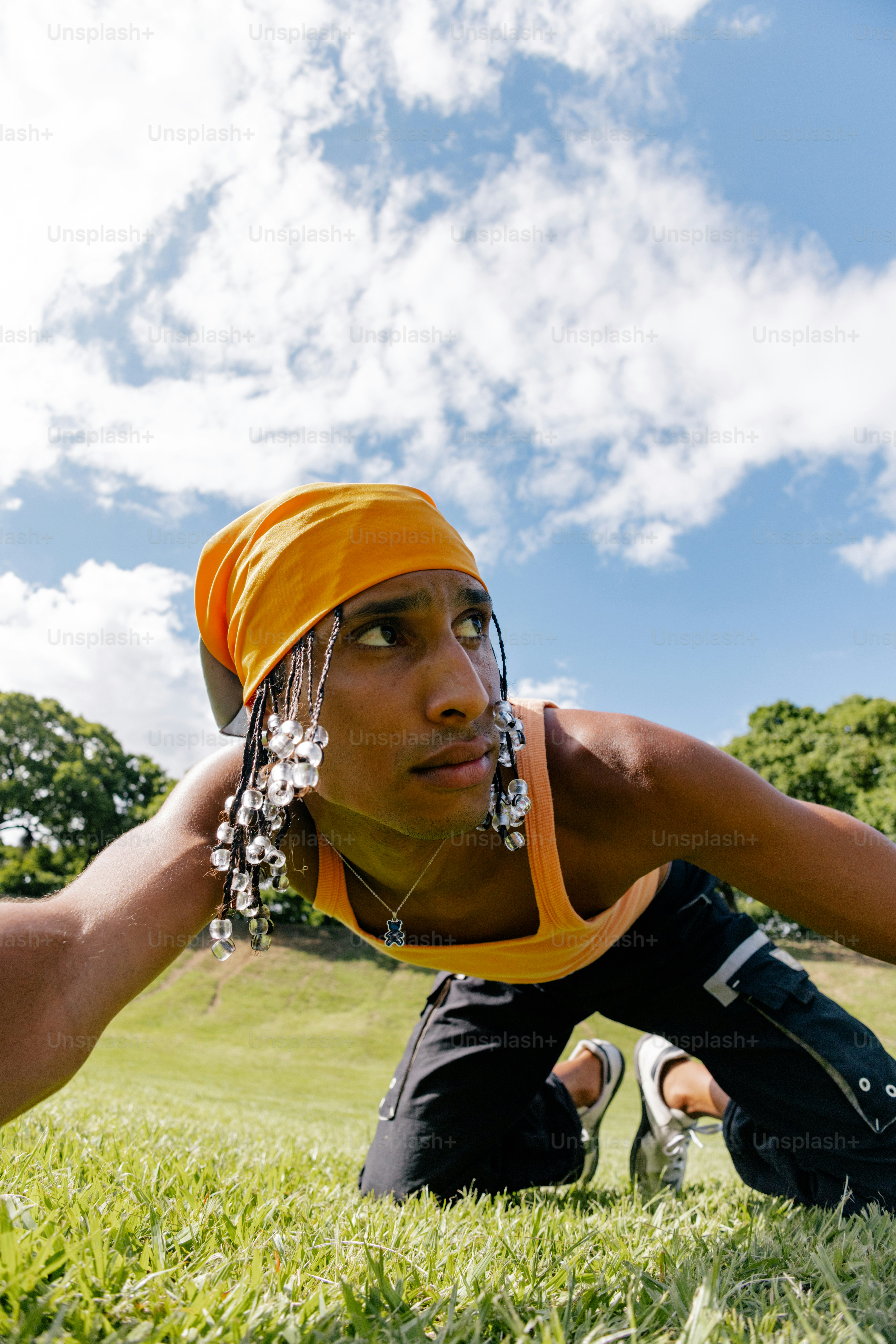 ヘッドスカーフを巻いて草むらに寝そべる女性