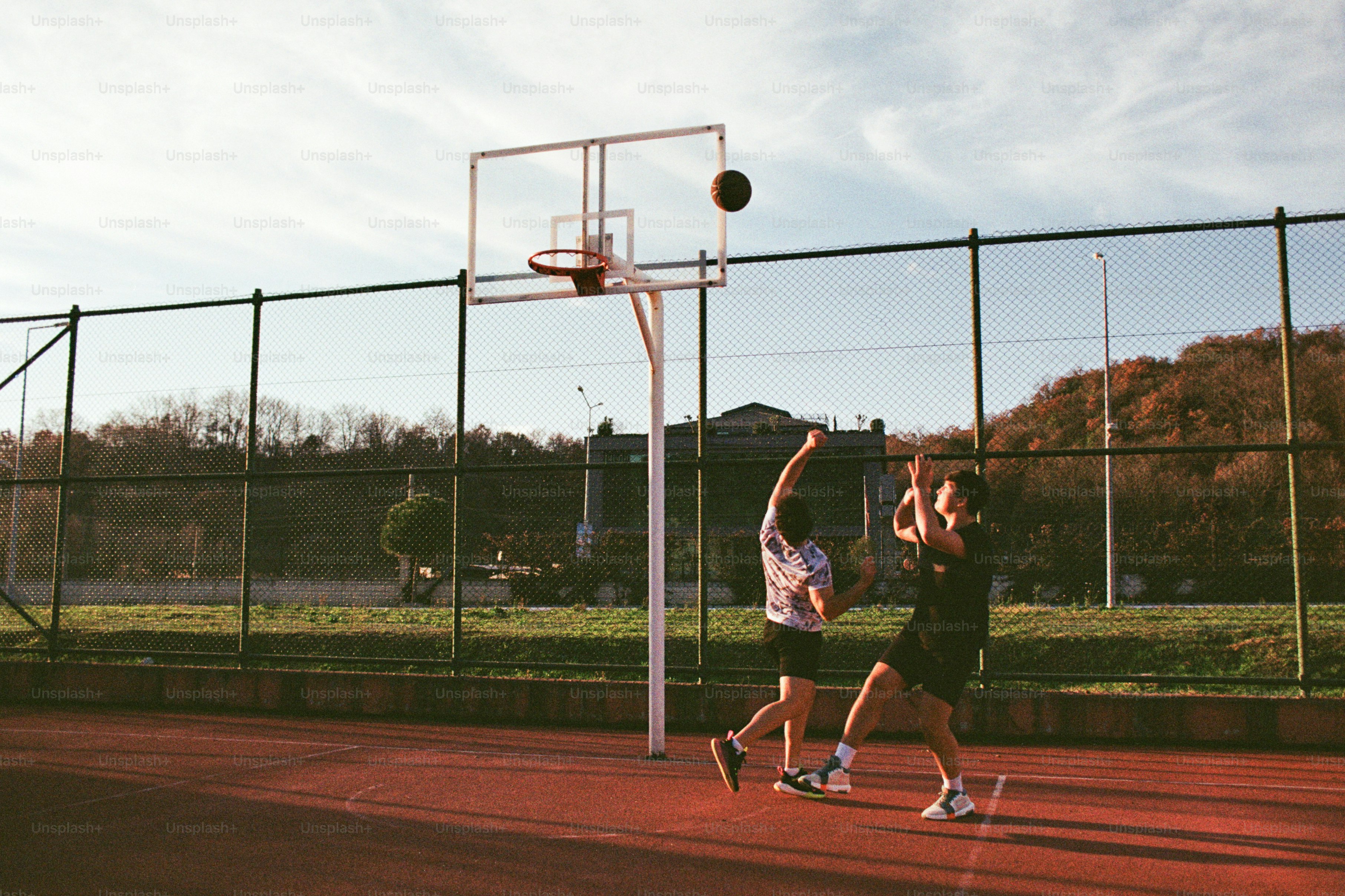 Two men are playing basketball on a court