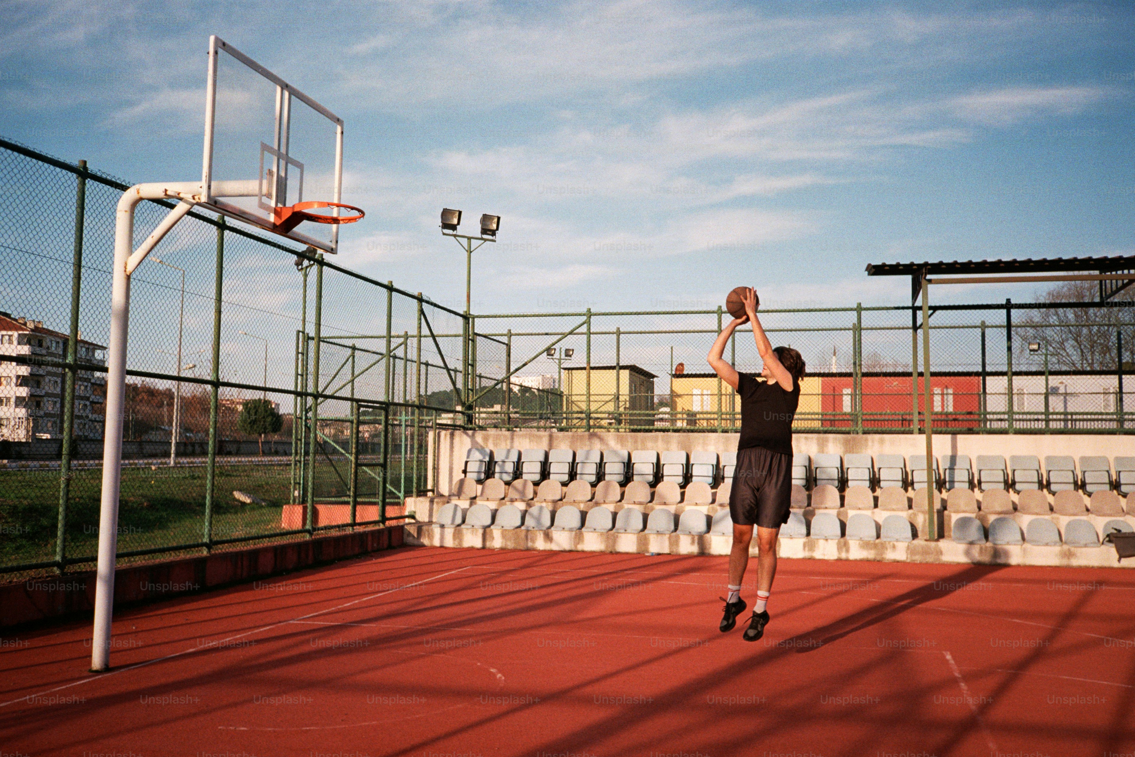 농구공을 들고 농구 코트에 서 있는 남자