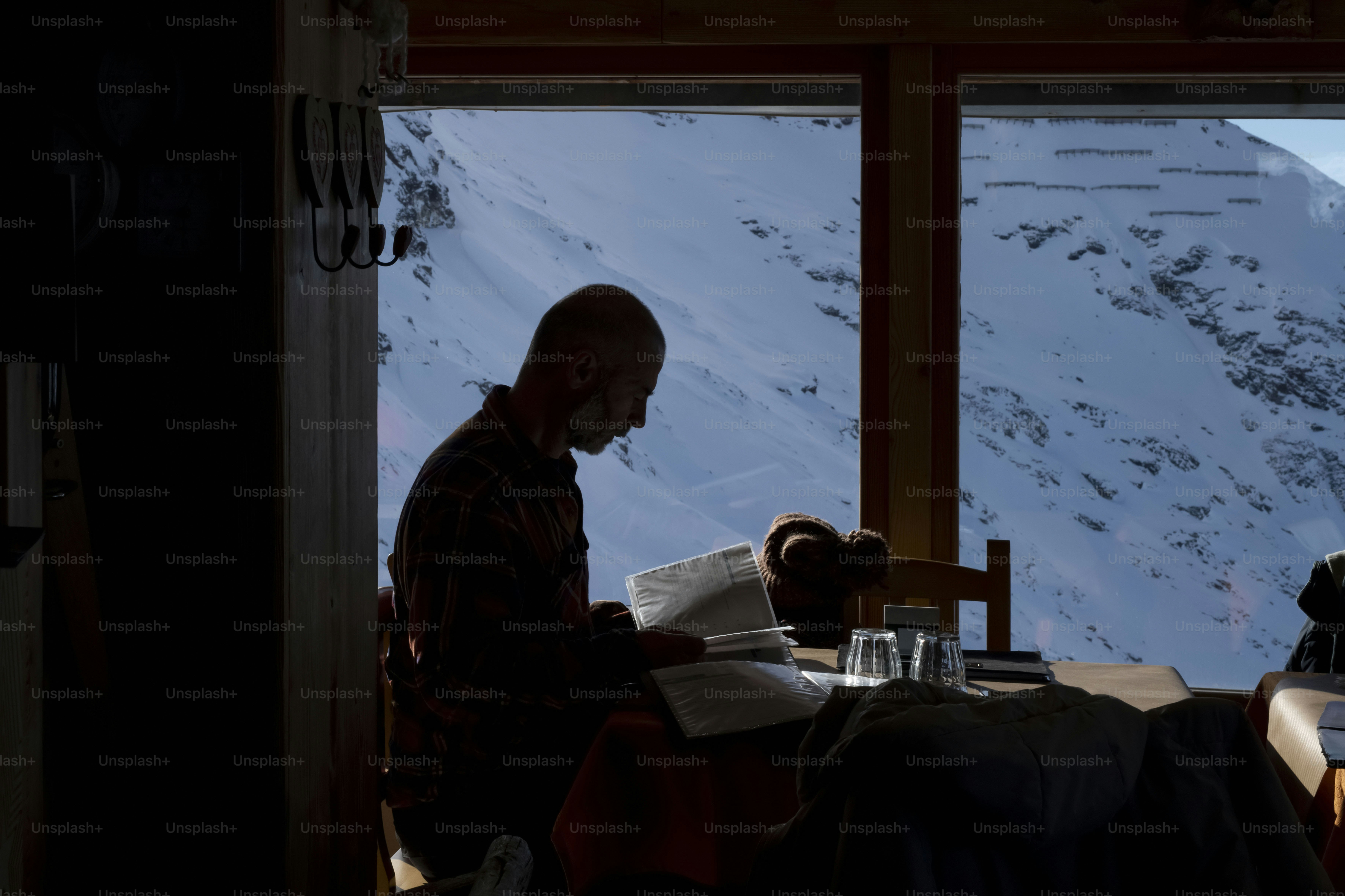 Un hombre sentado en una mesa frente a una ventana