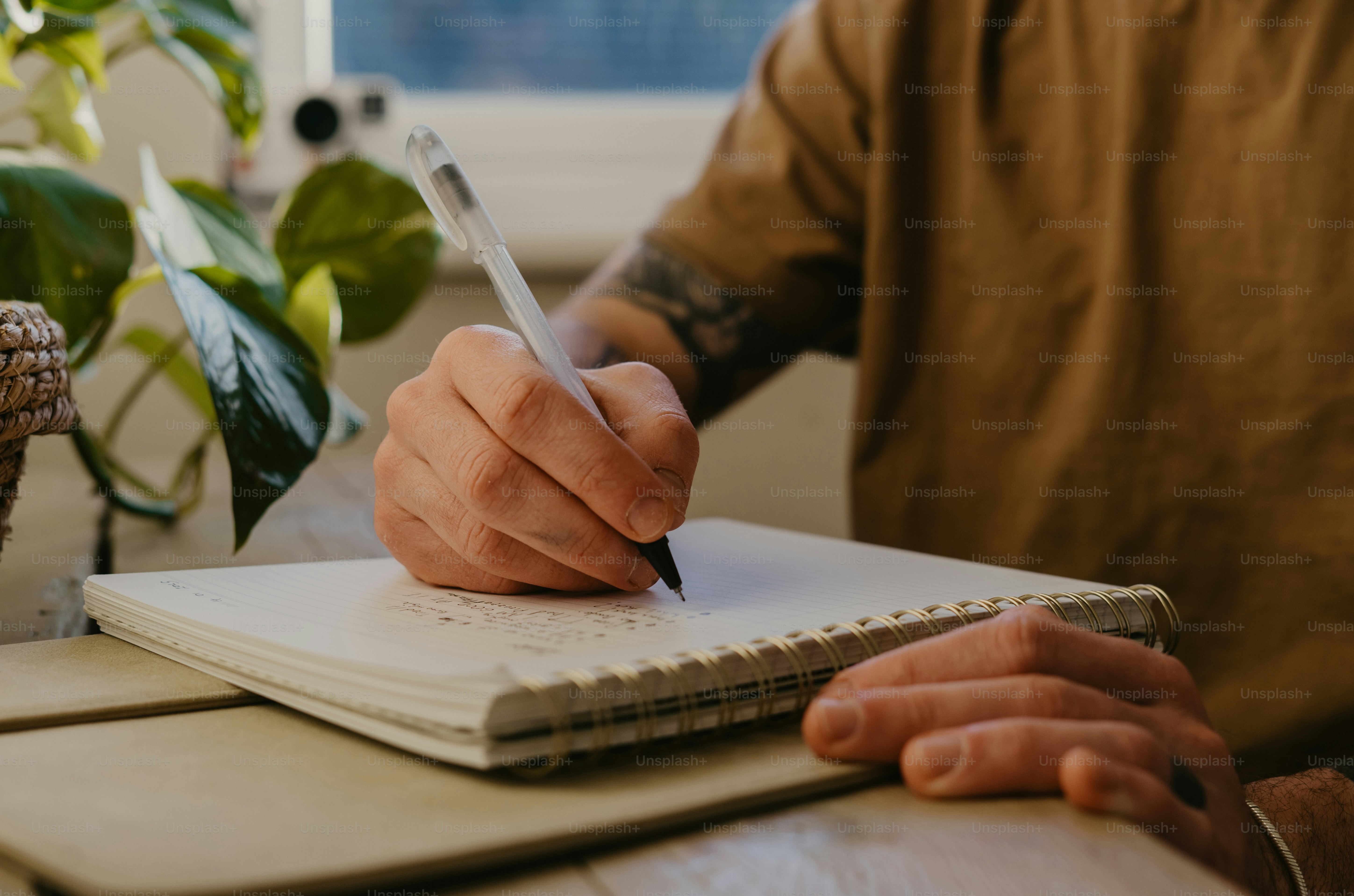 Seorang pria duduk di meja menulis di buku catatan