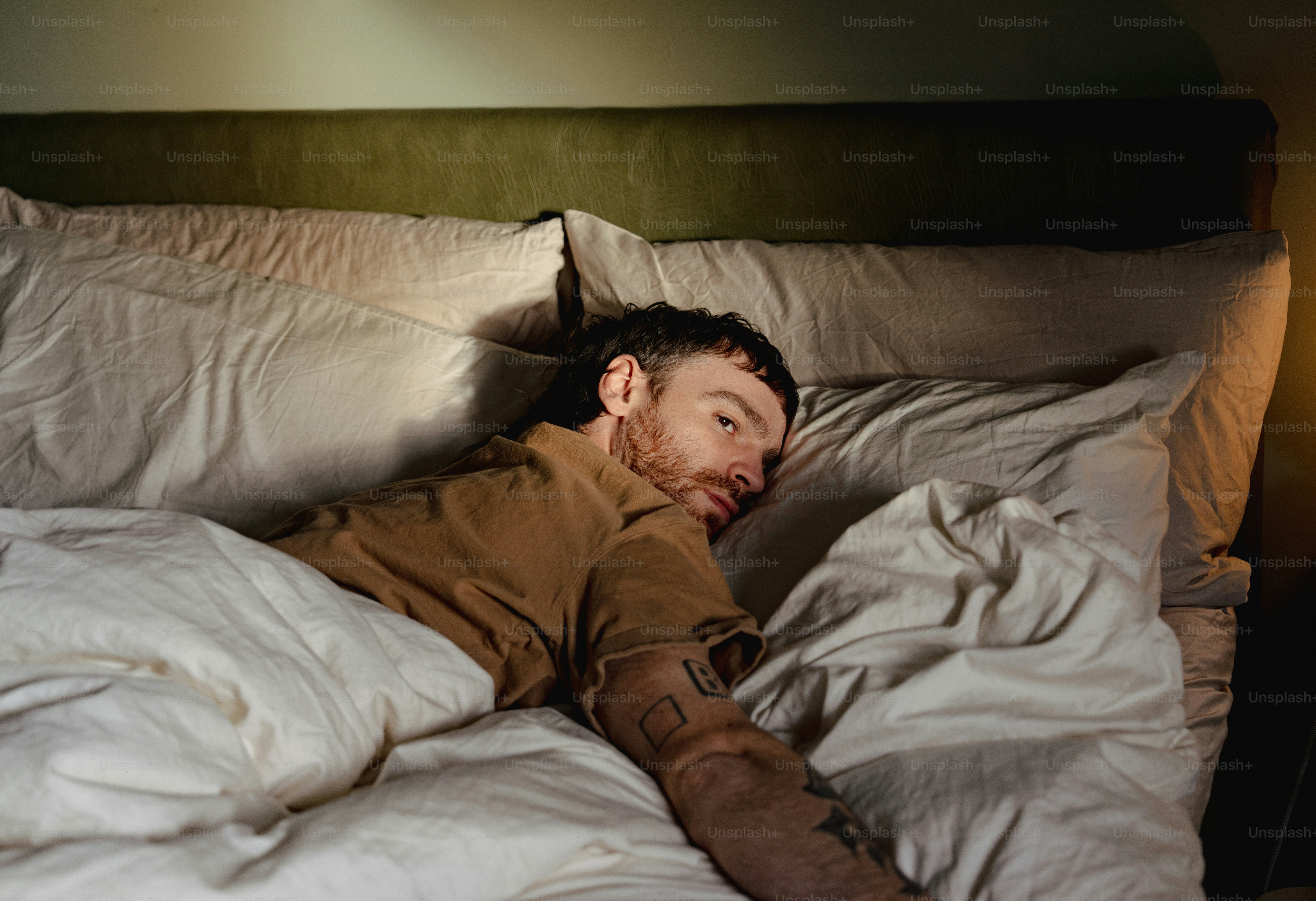 A man laying in bed with his head on the pillow photo – Depression ...
