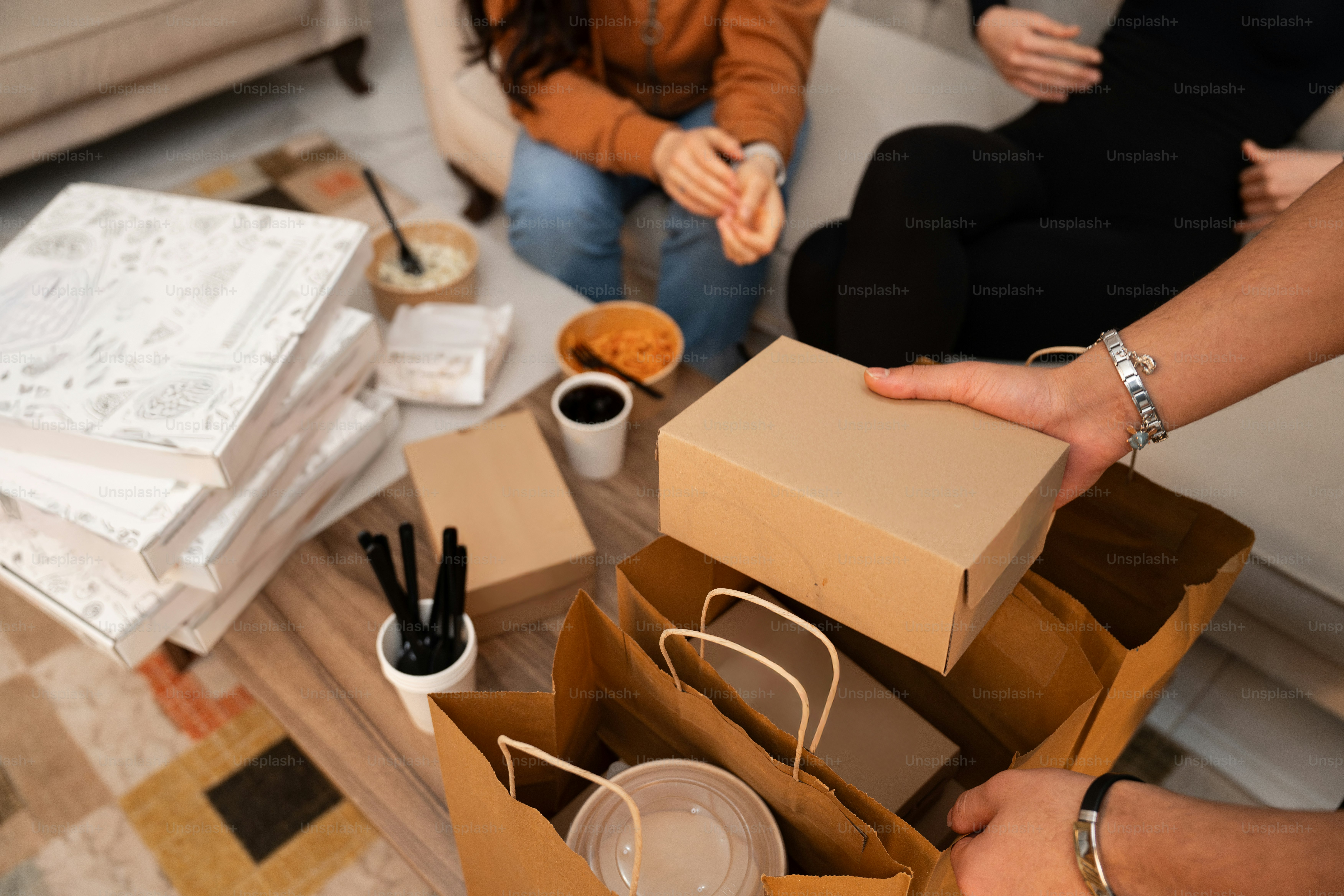 상자가 놓인 테이블 주위에 앉아있는 한 무리의 사람들