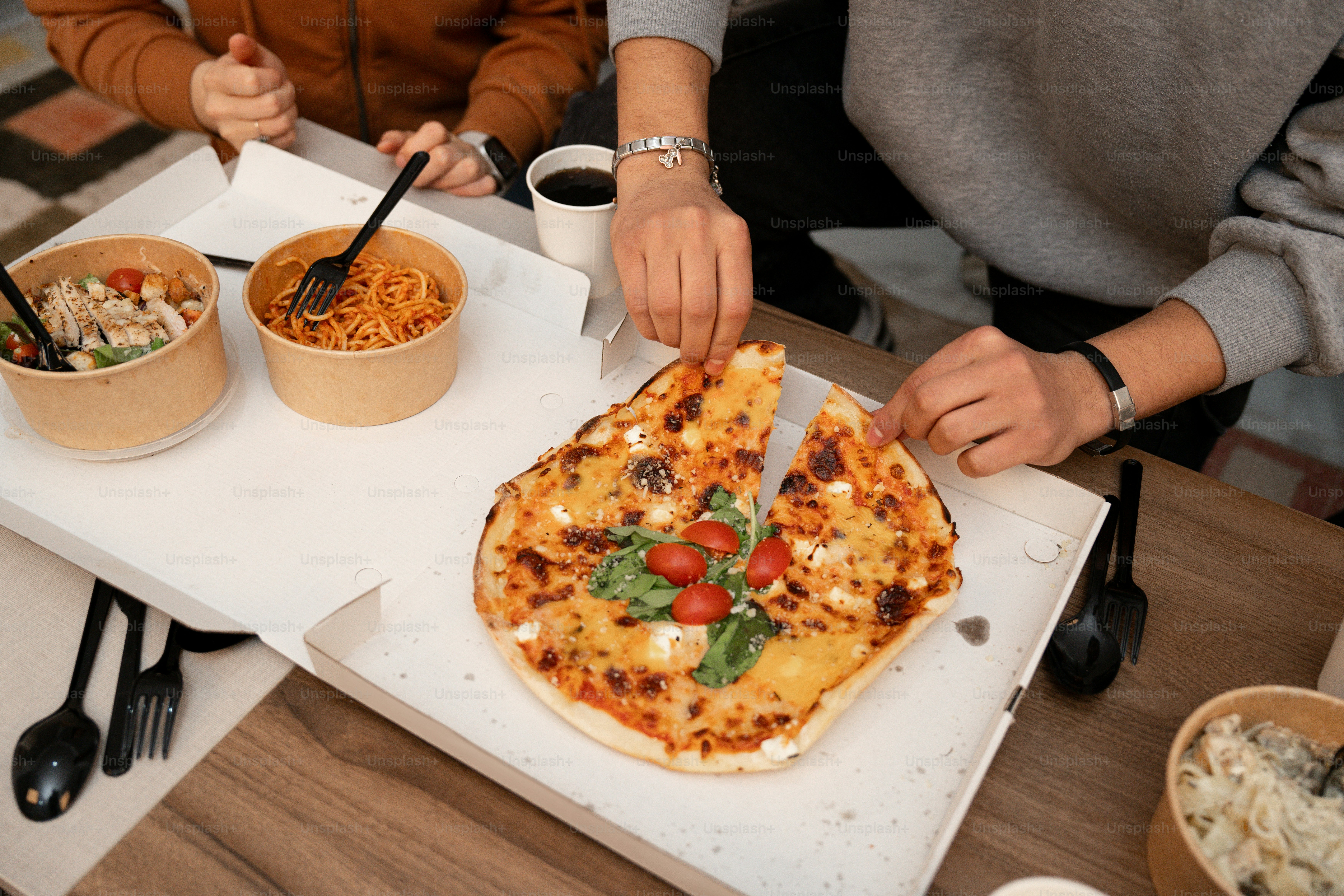 A person cutting a pizza on a cutting board