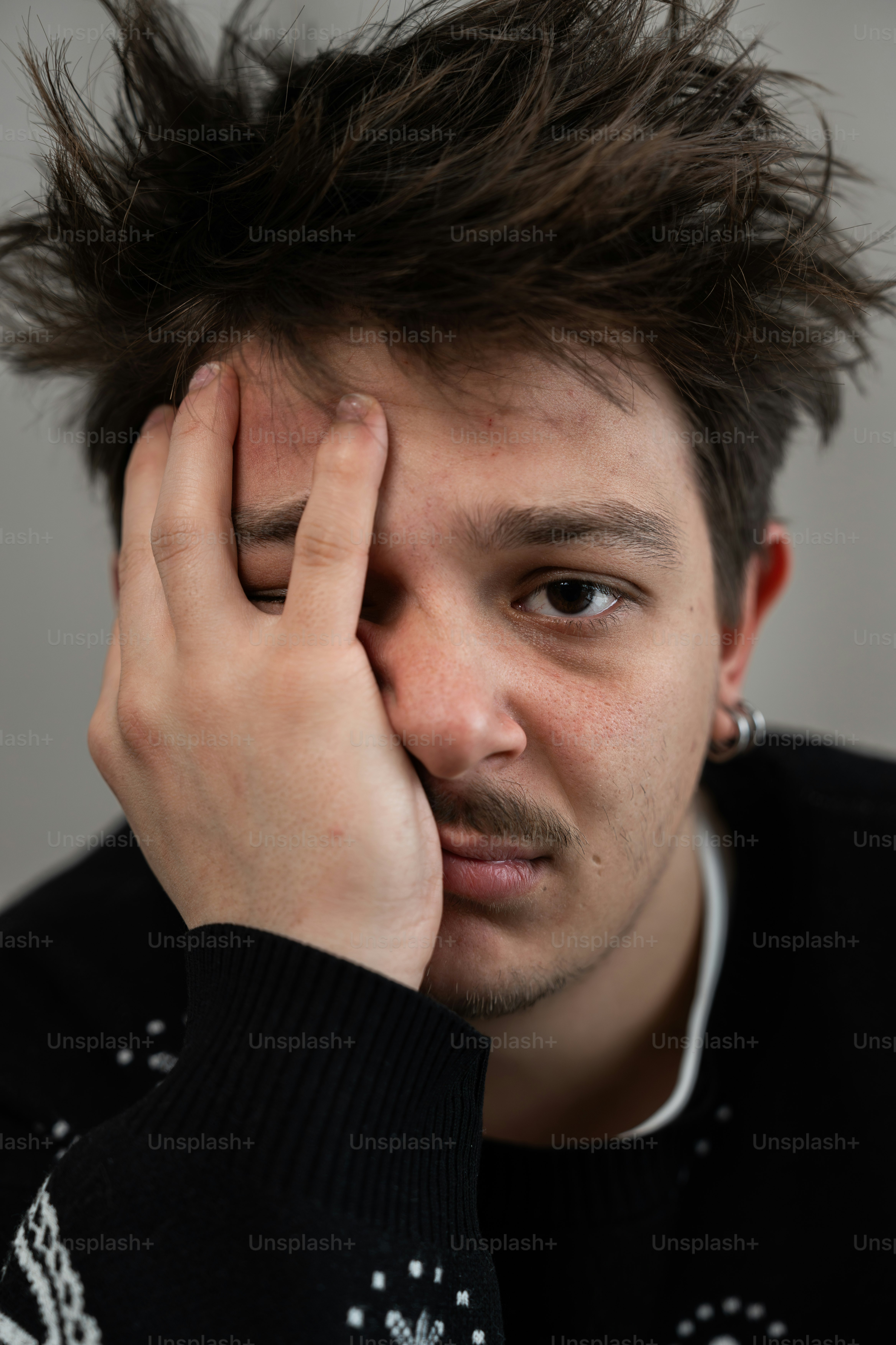 A man with his hand on his face