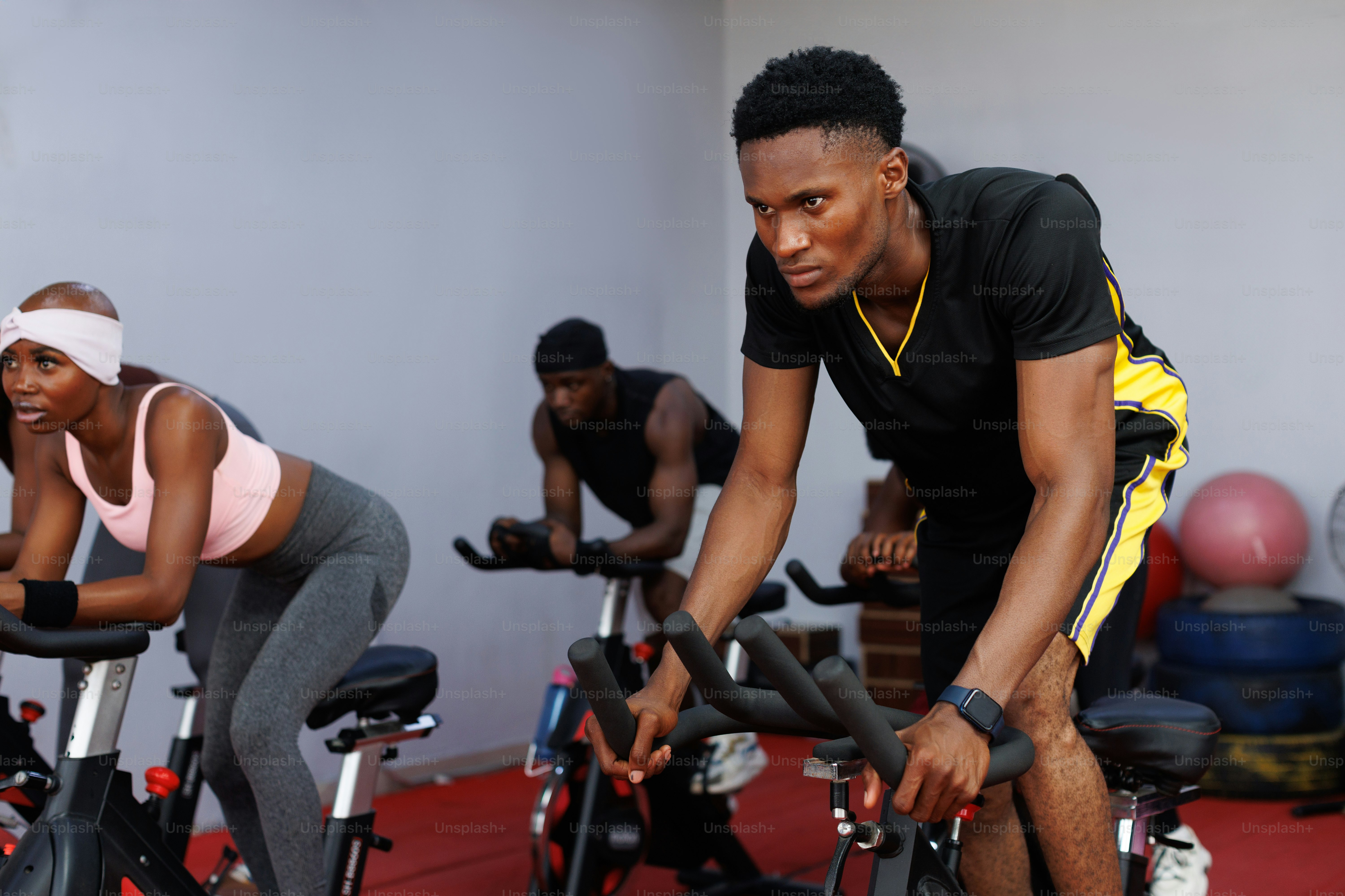 A group of people riding stationary bikes in a gym