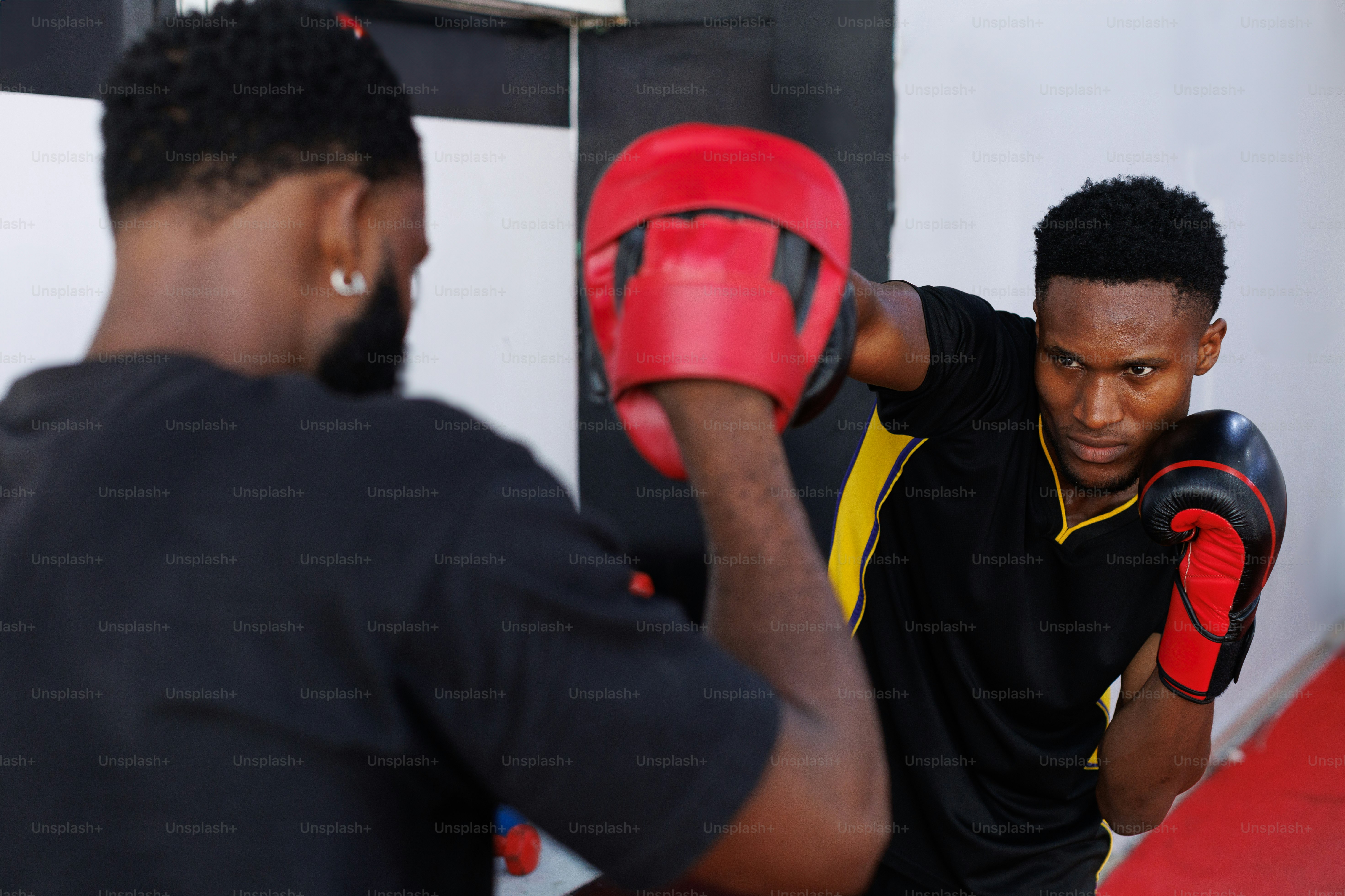 A couple of men standing next to each other near a punching bag
