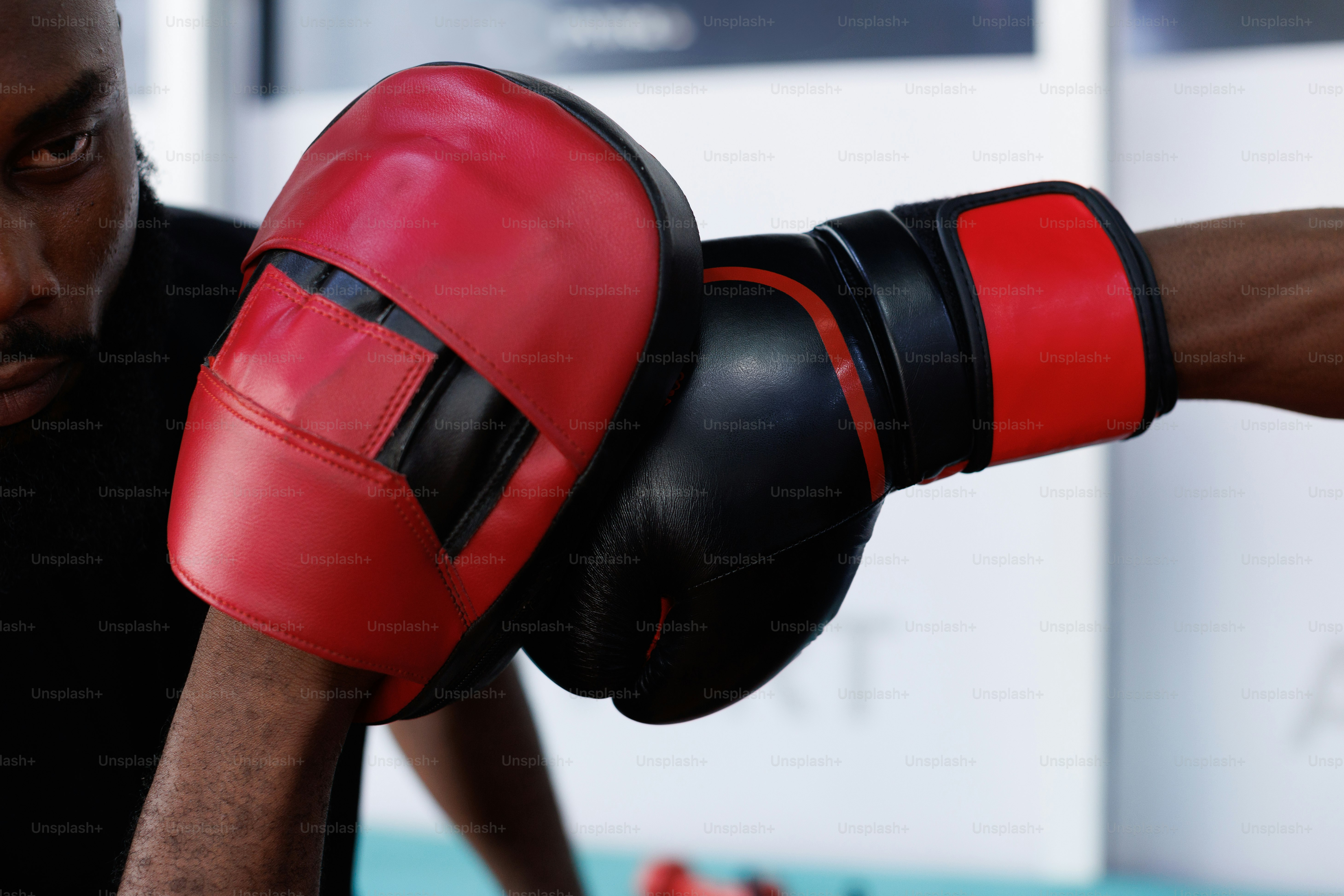 A man in a black shirt and red boxing gloves