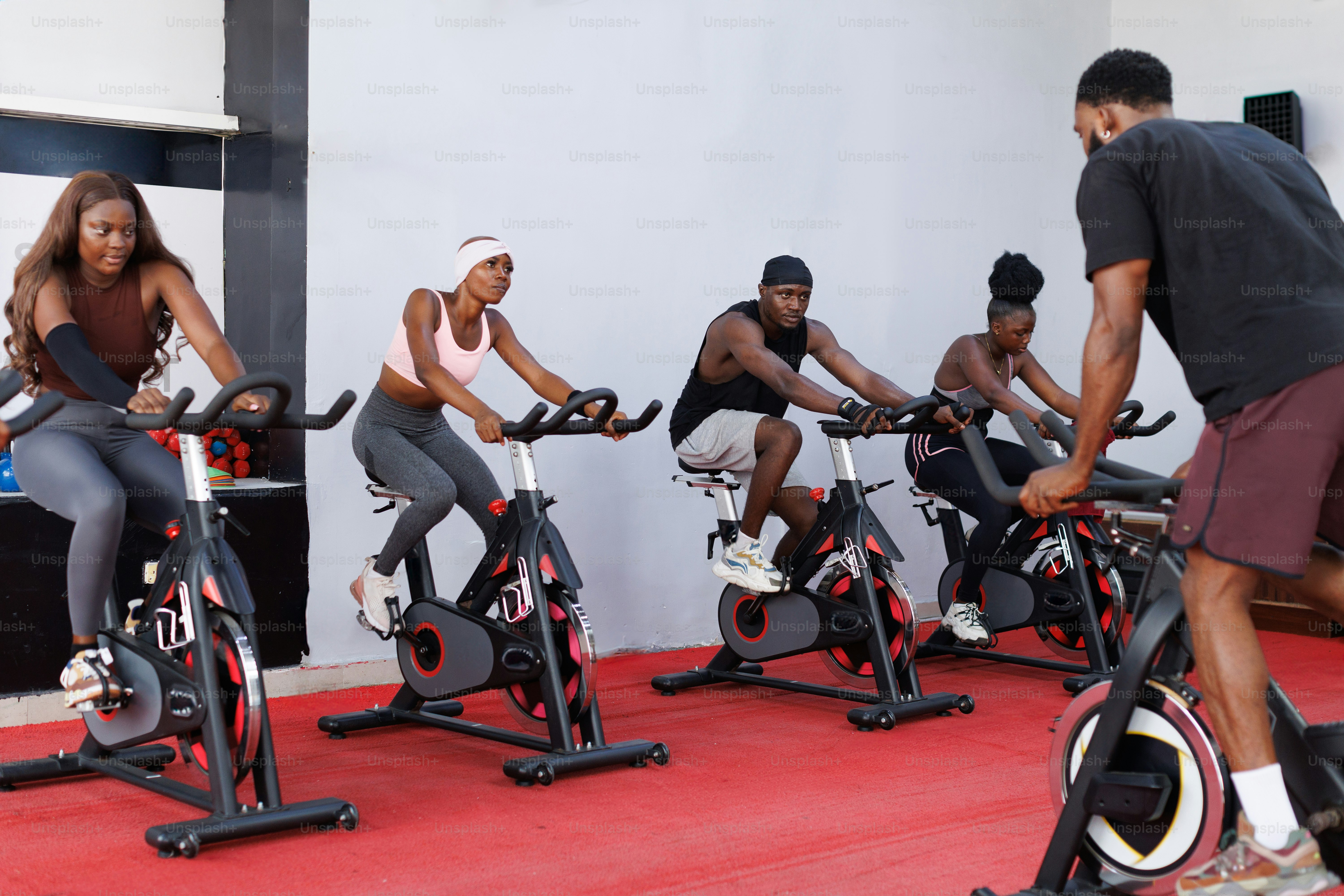 A group of people riding stationary bikes in a gym
