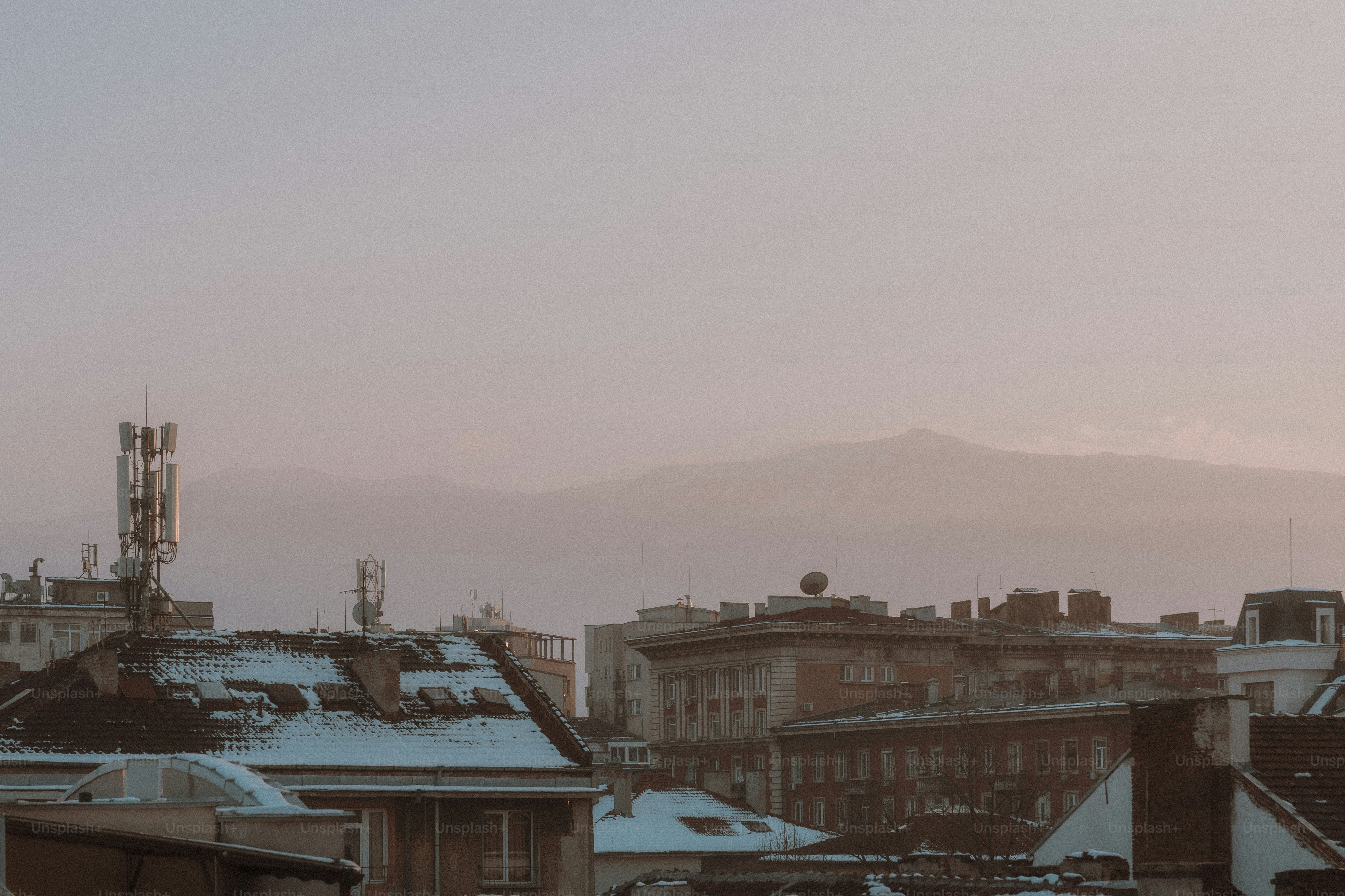 Uma vista de uma cidade com neve nos telhados