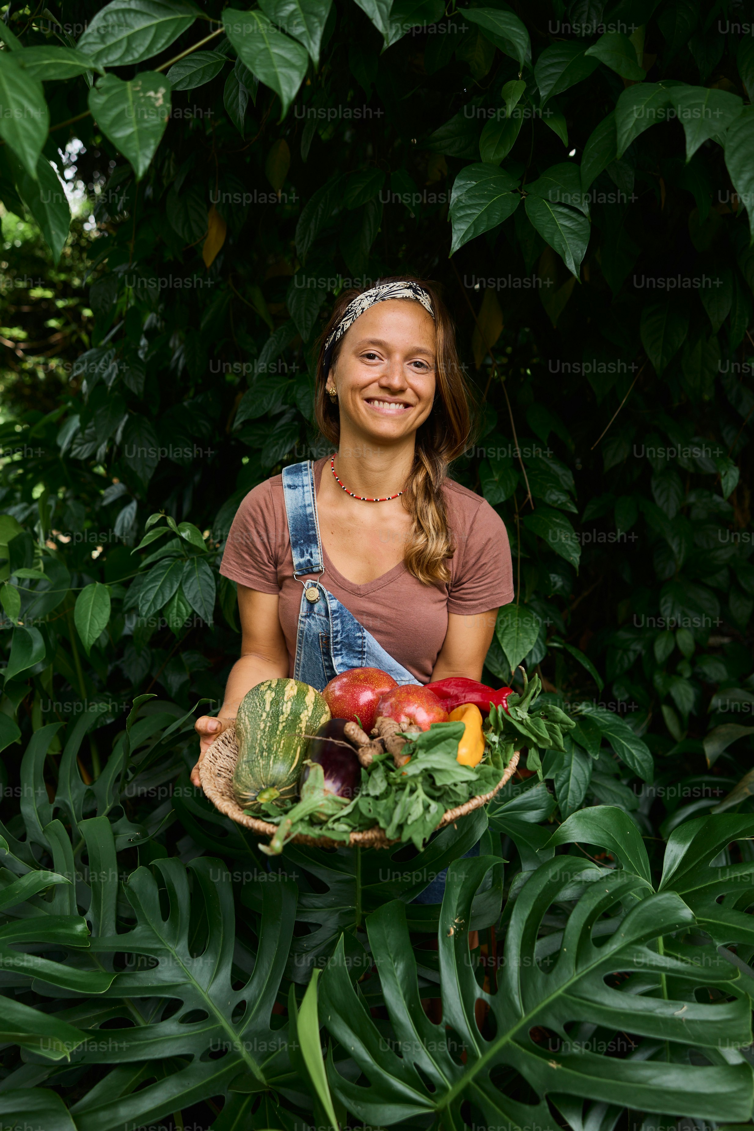 A woman holding a basket of fruit and vegetables