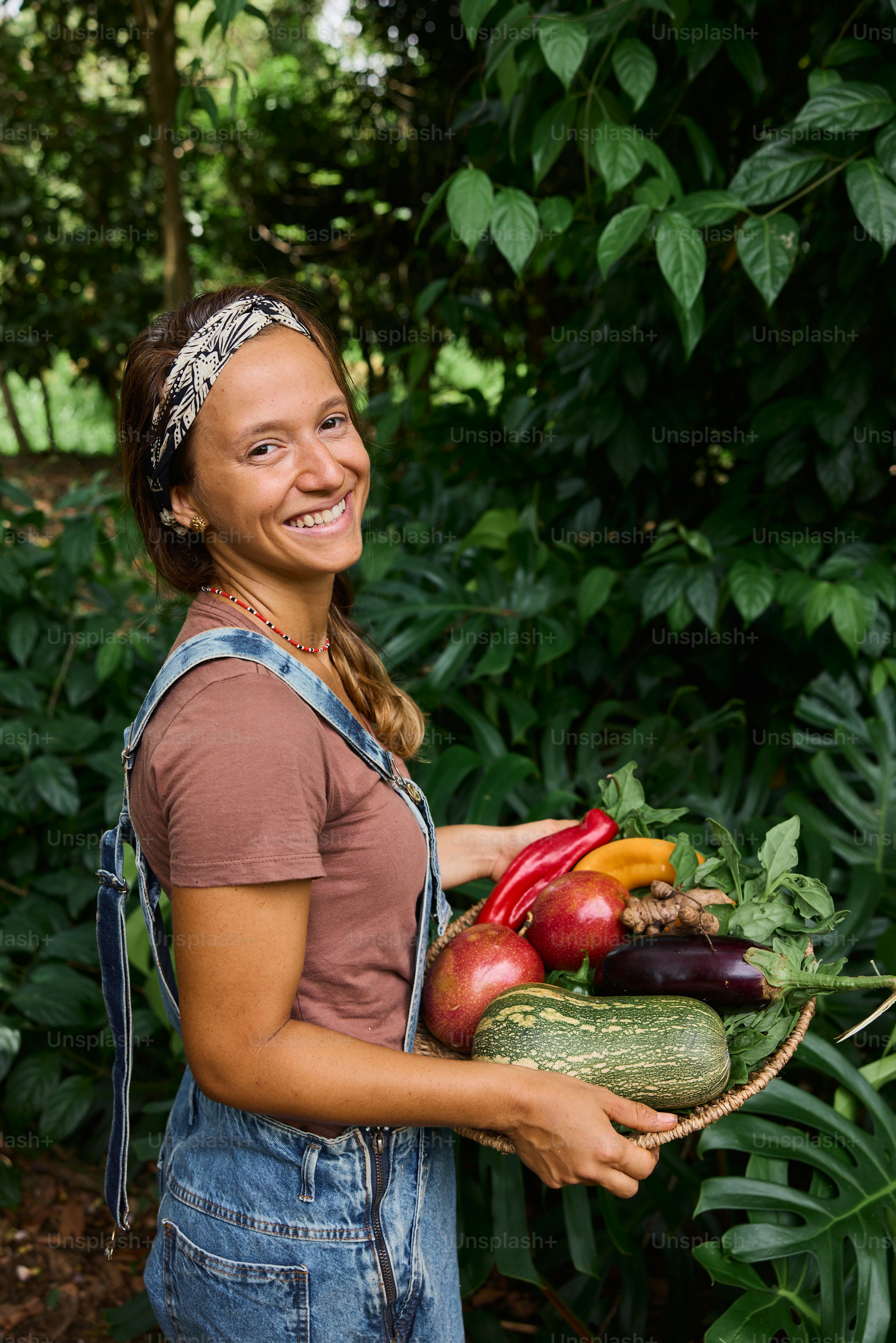 Una donna che tiene un cesto pieno di verdure