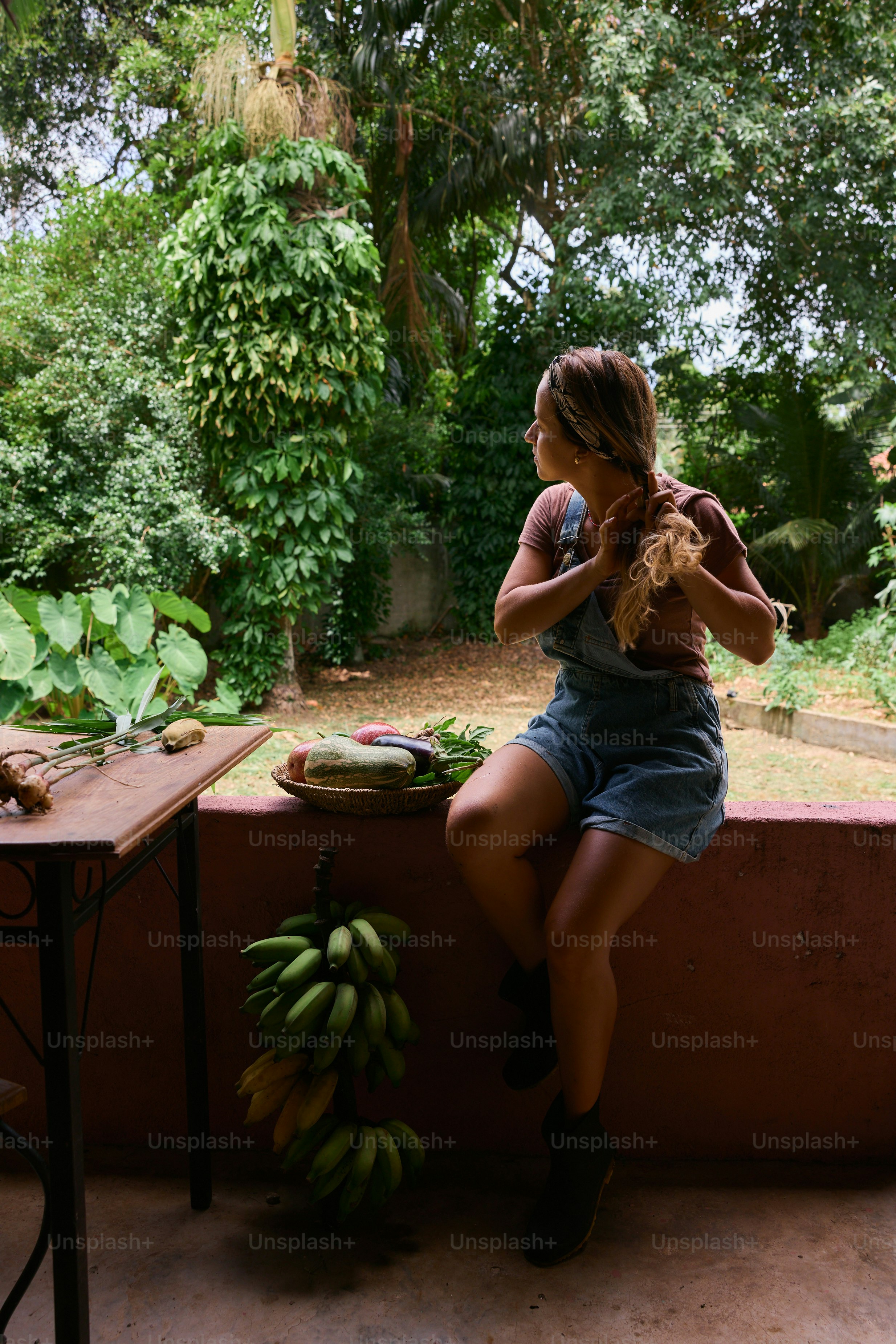 A woman sitting at a table with a bunch of bananas