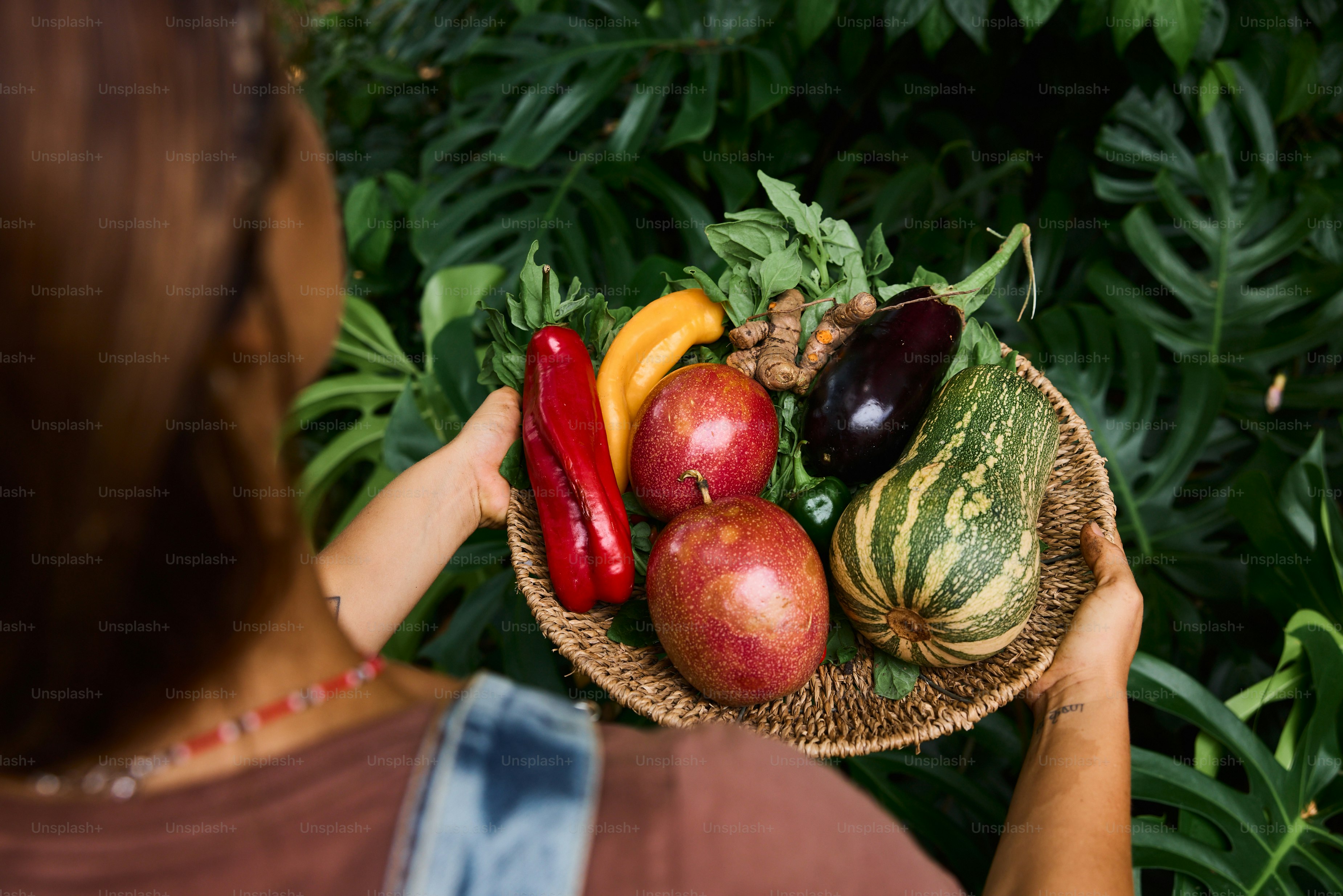 A woman holding a basket of fruit and vegetables