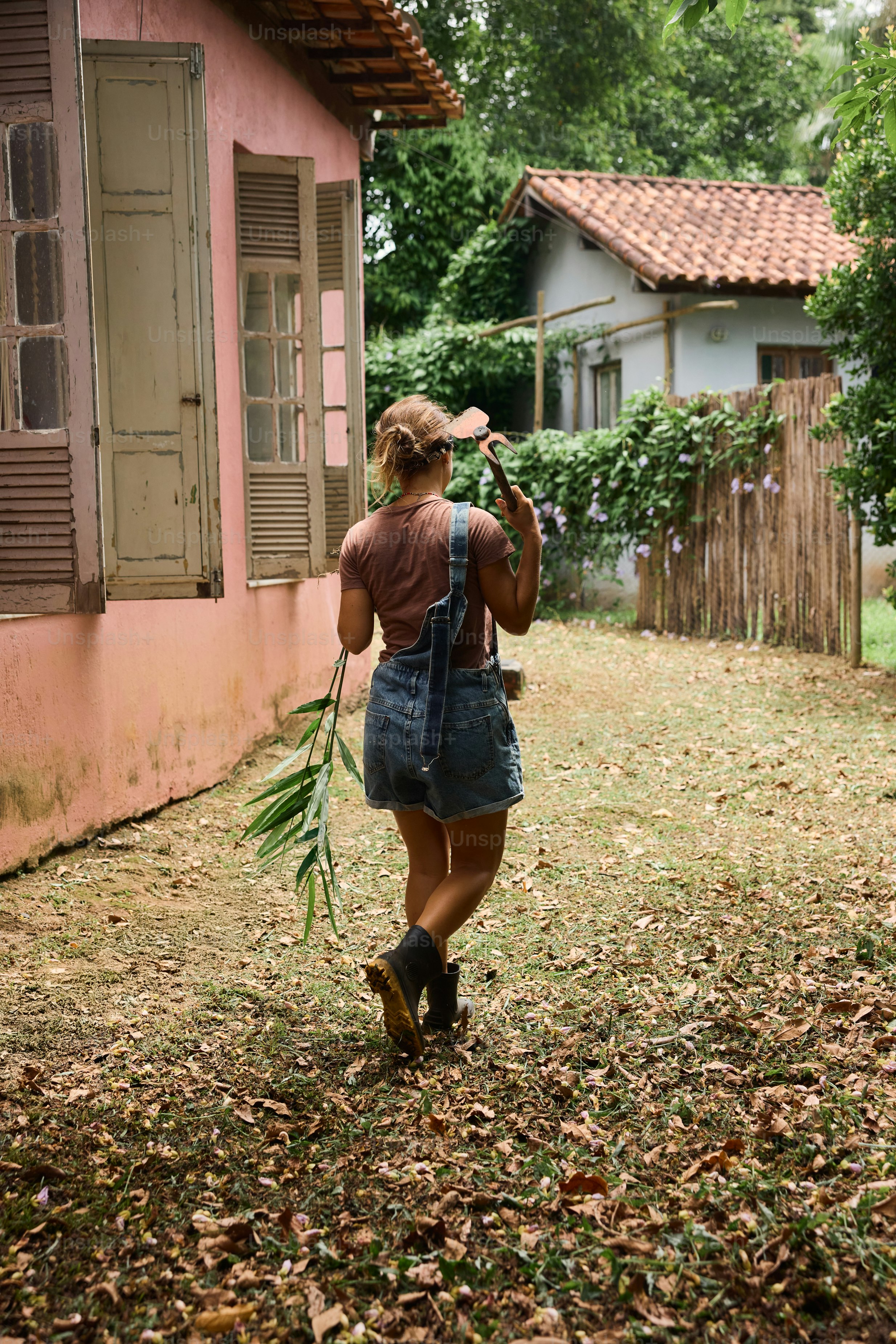 A woman walking down a leaf covered street