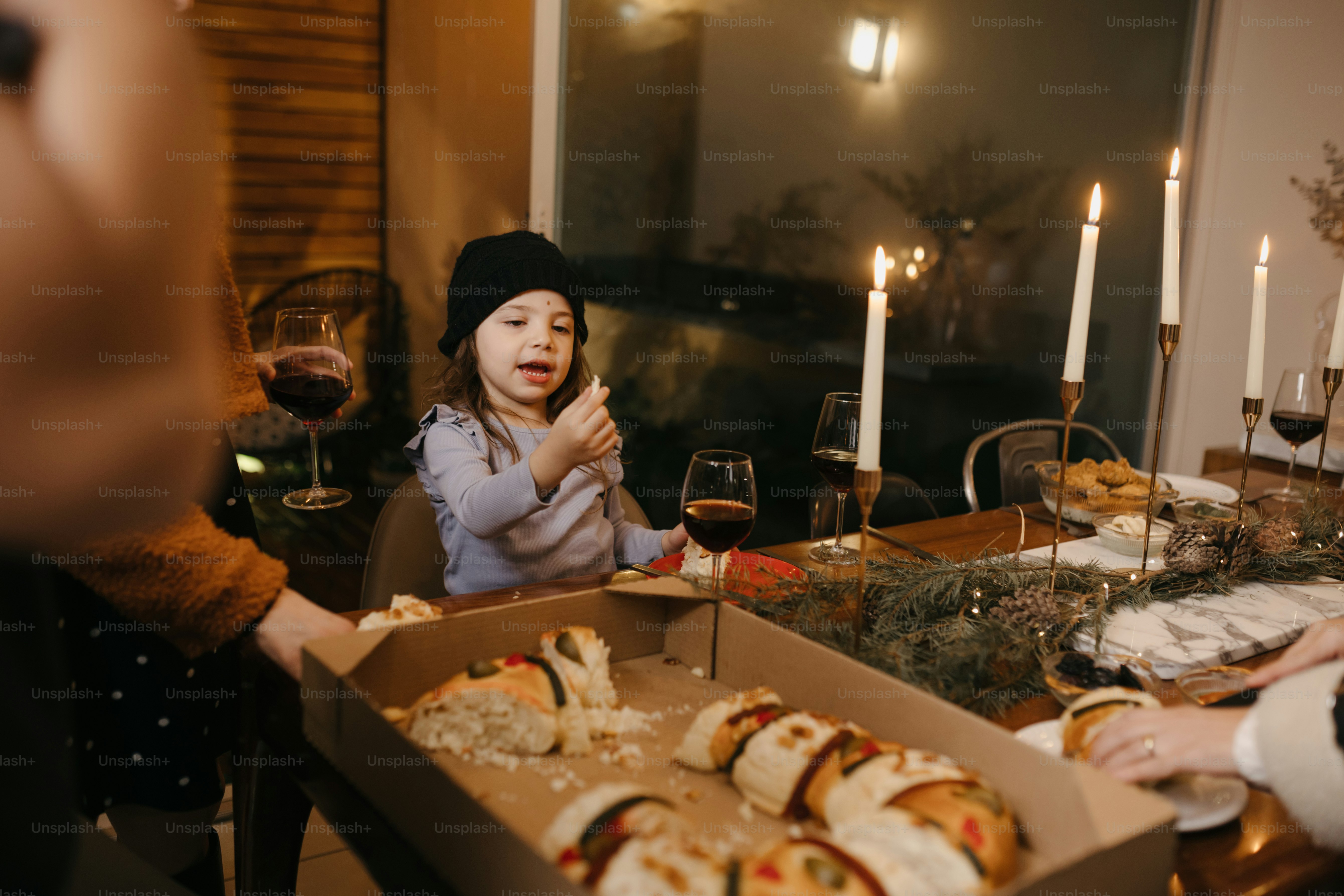 A group of people standing around a table filled with food photo ...